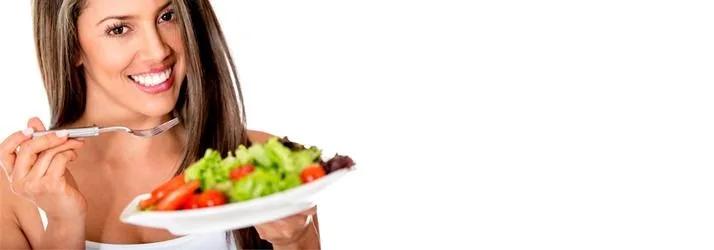 Smiling woman holding a fork and a plate of salad