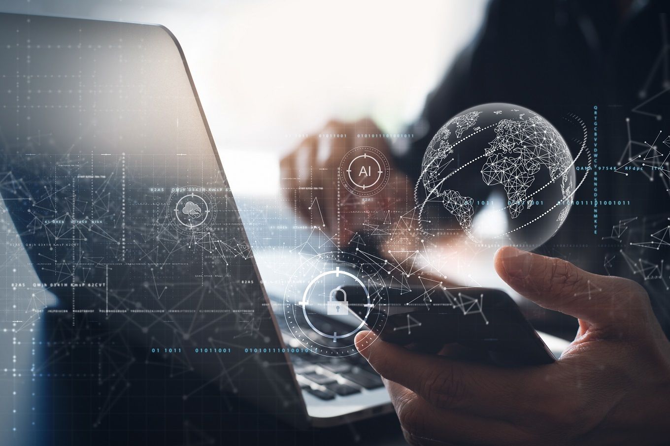 A man is using a laptop and a mobile