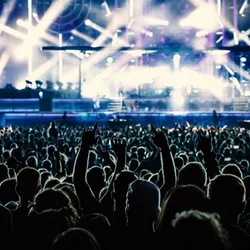Image of concert with people enjoying event.