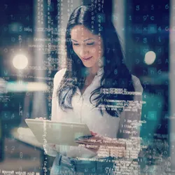 A woman is using a tablet in front of a screen