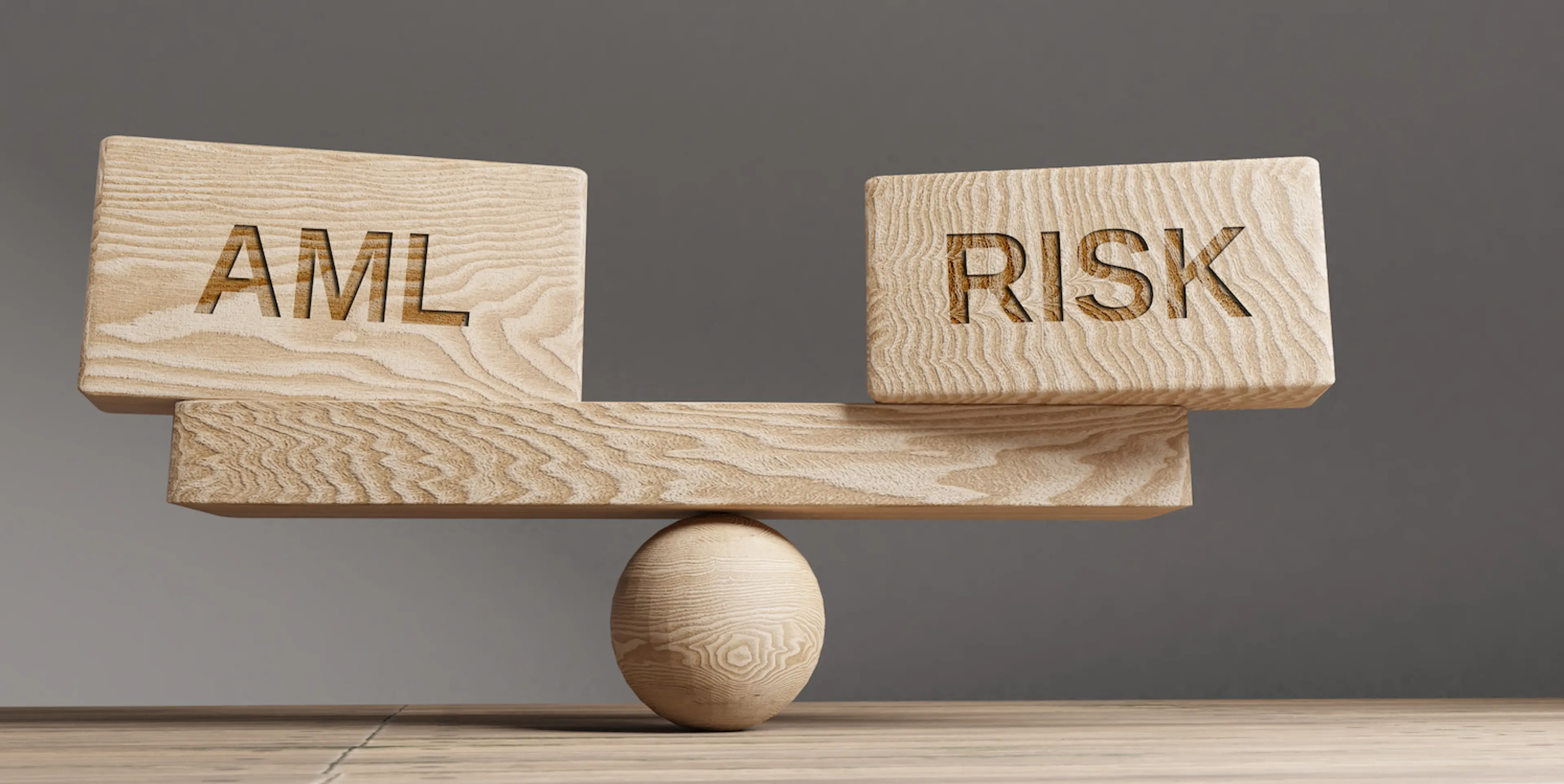 An image showing the balance between AML and Risk with help of wooden pieces