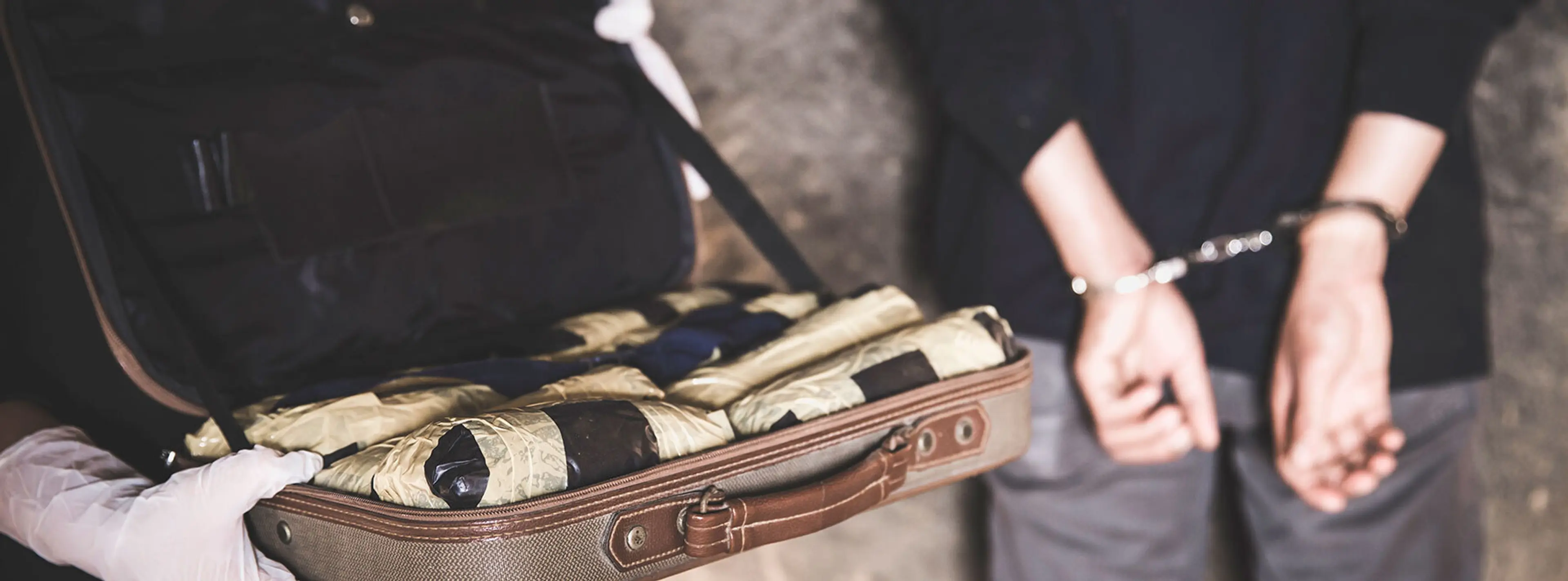 A man with handcuffs and a briefcase full of something