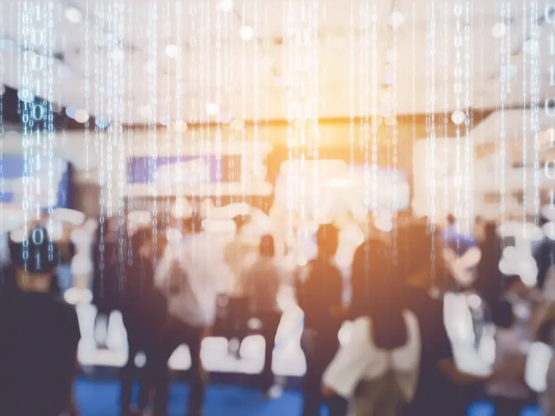 A blurry image of people at a trade show