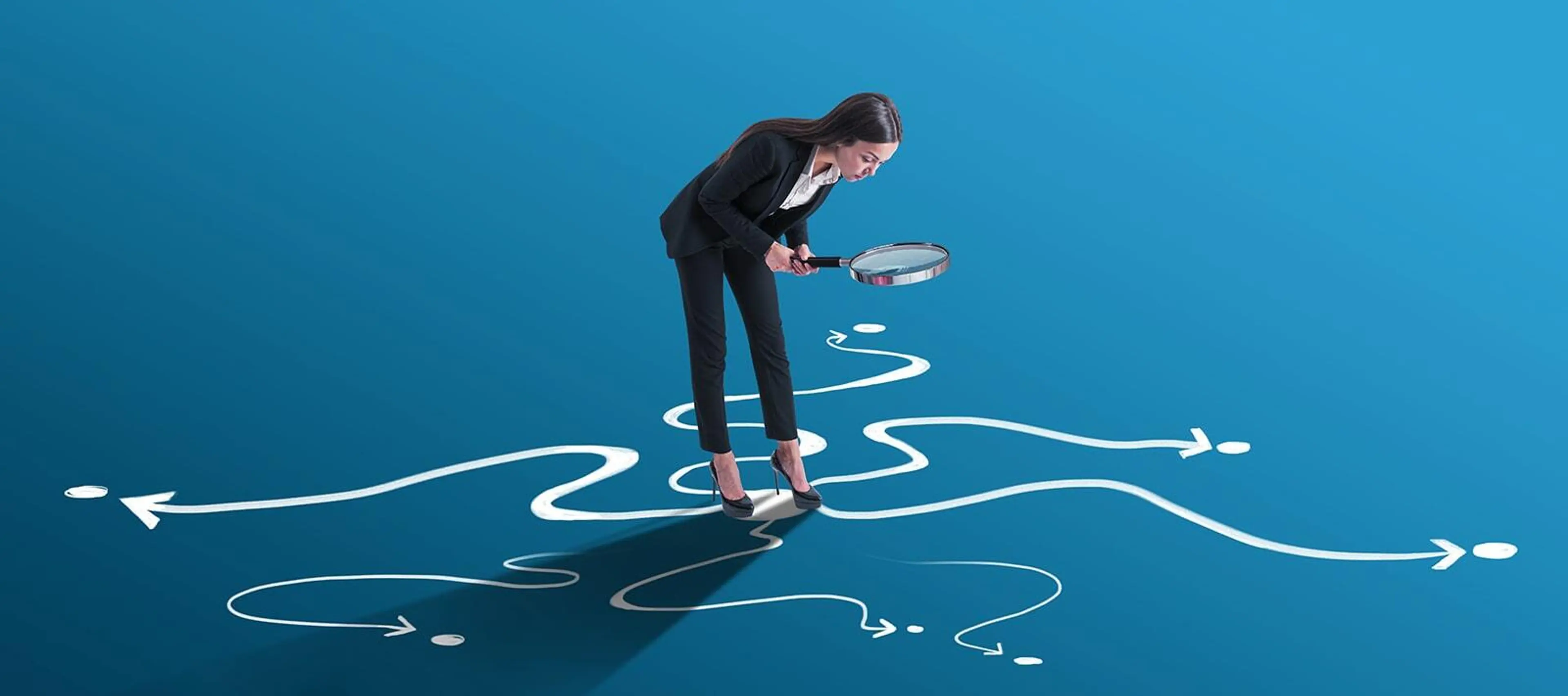 A woman holding magnifying glass and looking ground through it