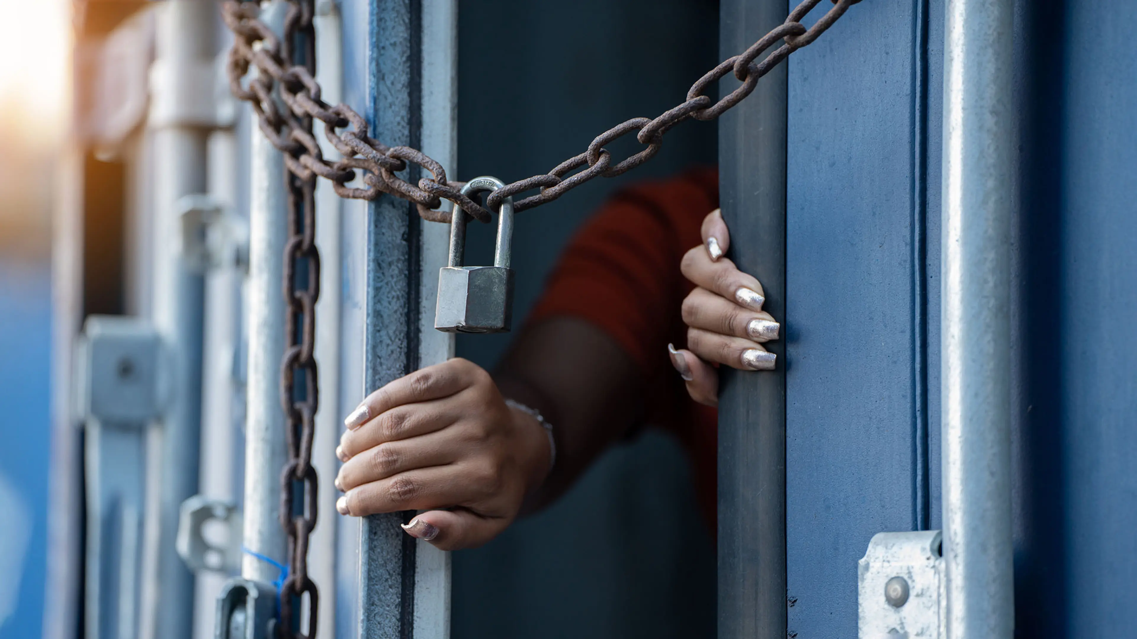 A hand reaches through a chained door