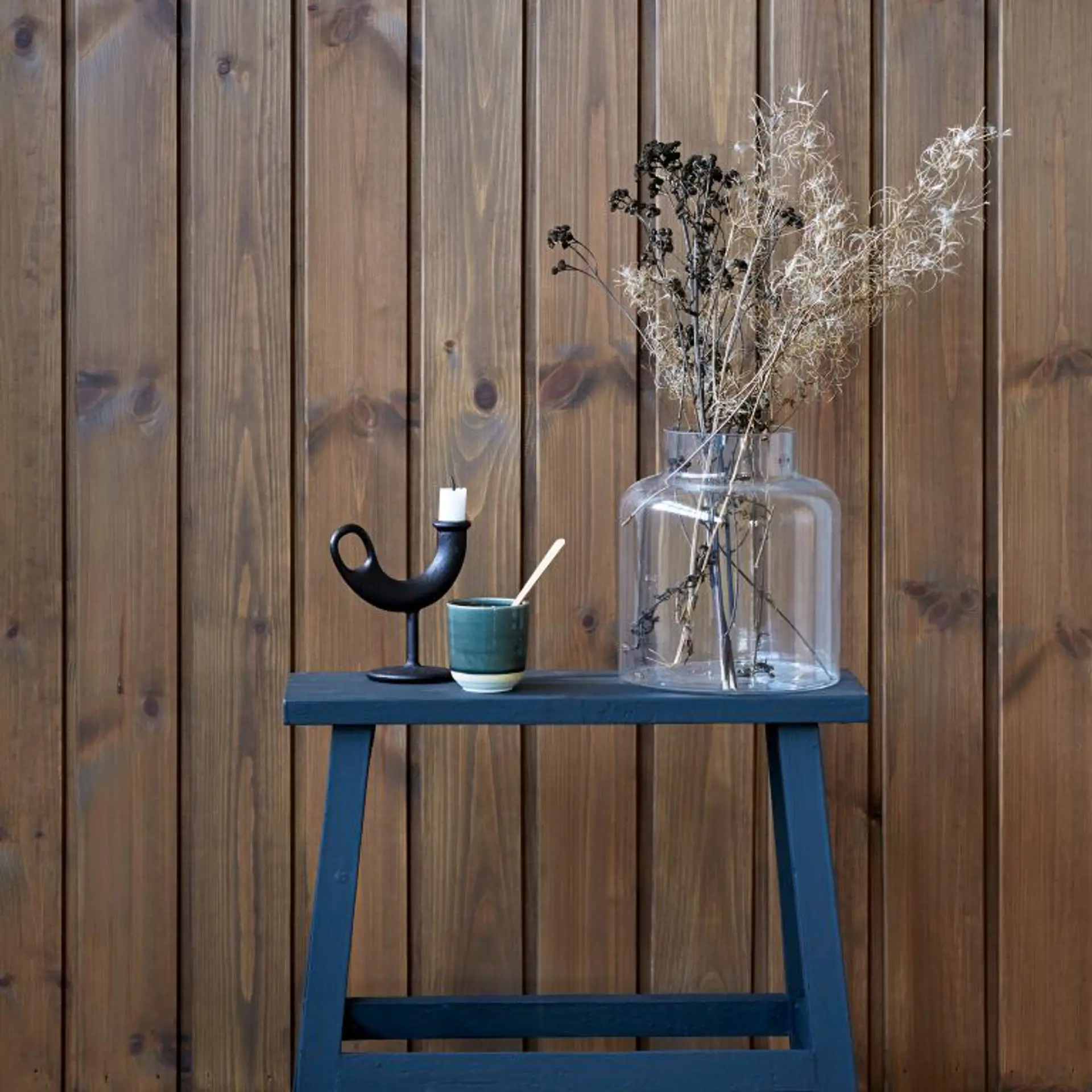 blå krakk står foran en brunbeiset vegg