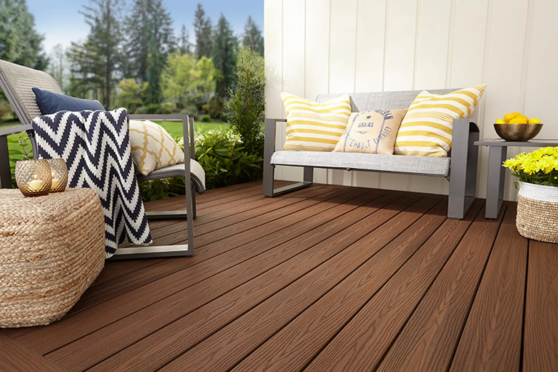 kompositt terrasse med moderne sofagruppe i grå aluminium og stripete puter i gult og blått
