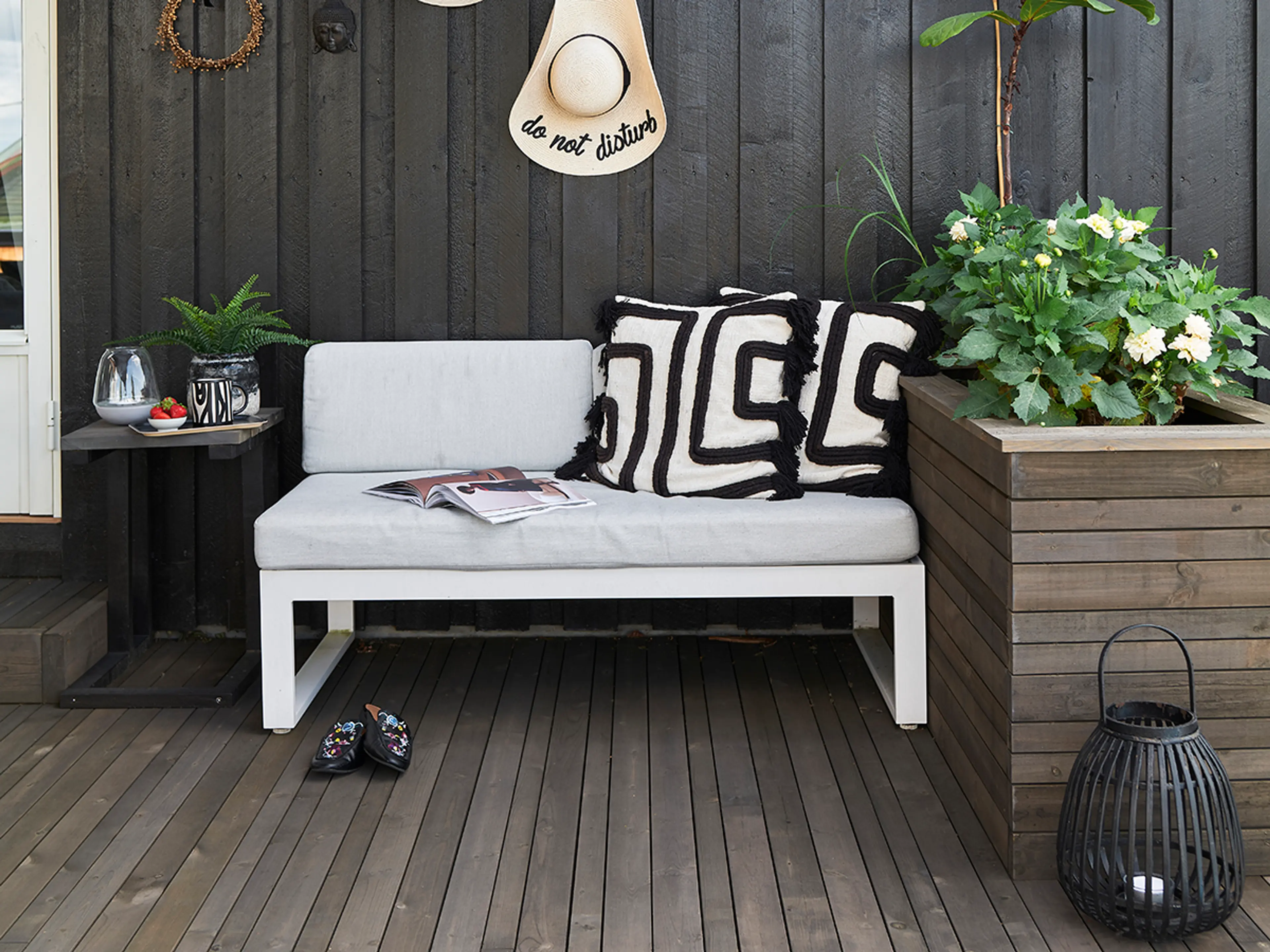 Terrasse og blomsterkasse bygget med Concise lekter fra Talgø. Møblert med hvit utesofa i aluminium og grønne planter