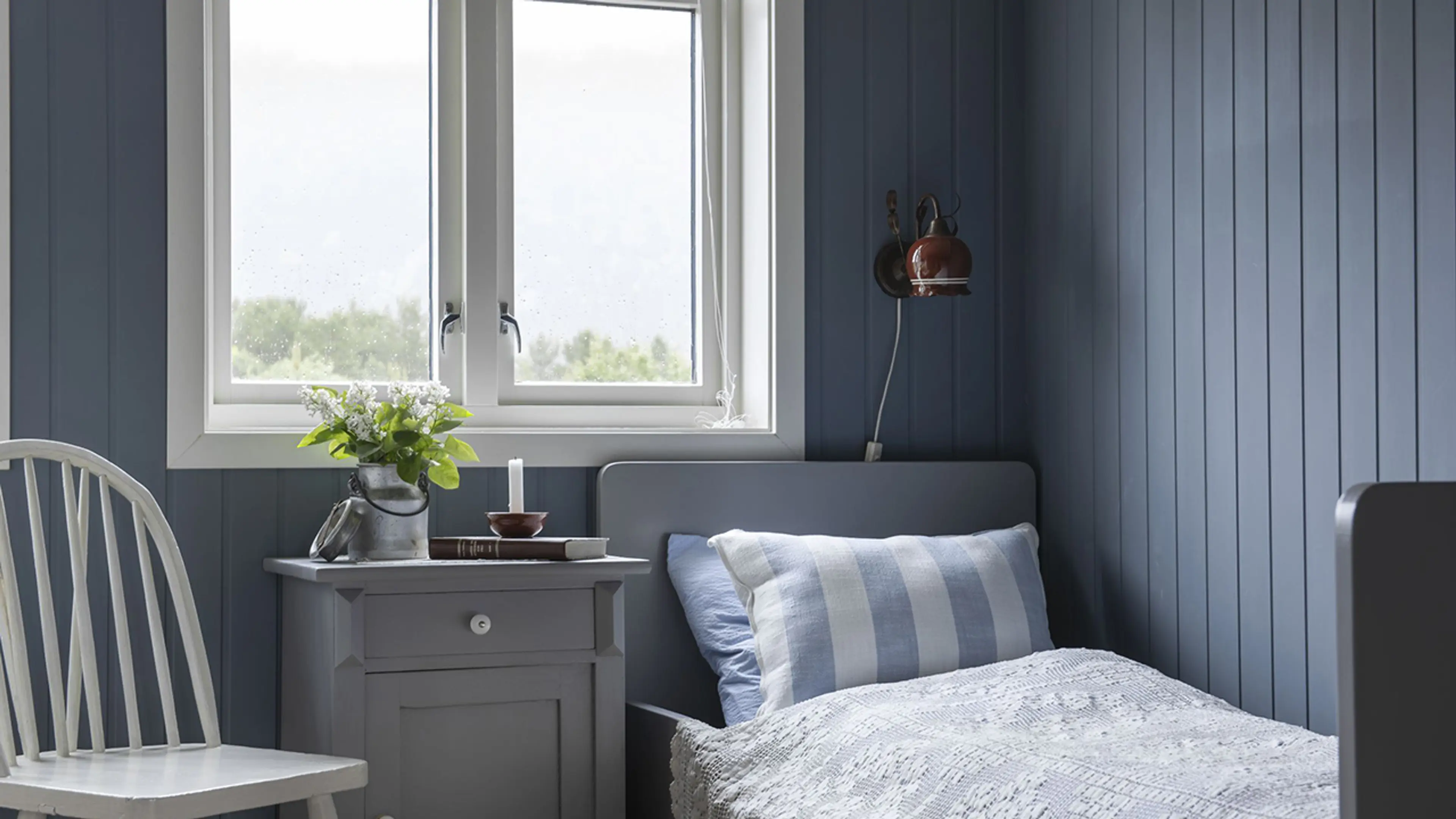 Hyttevegger i furupanel som er malt blå.