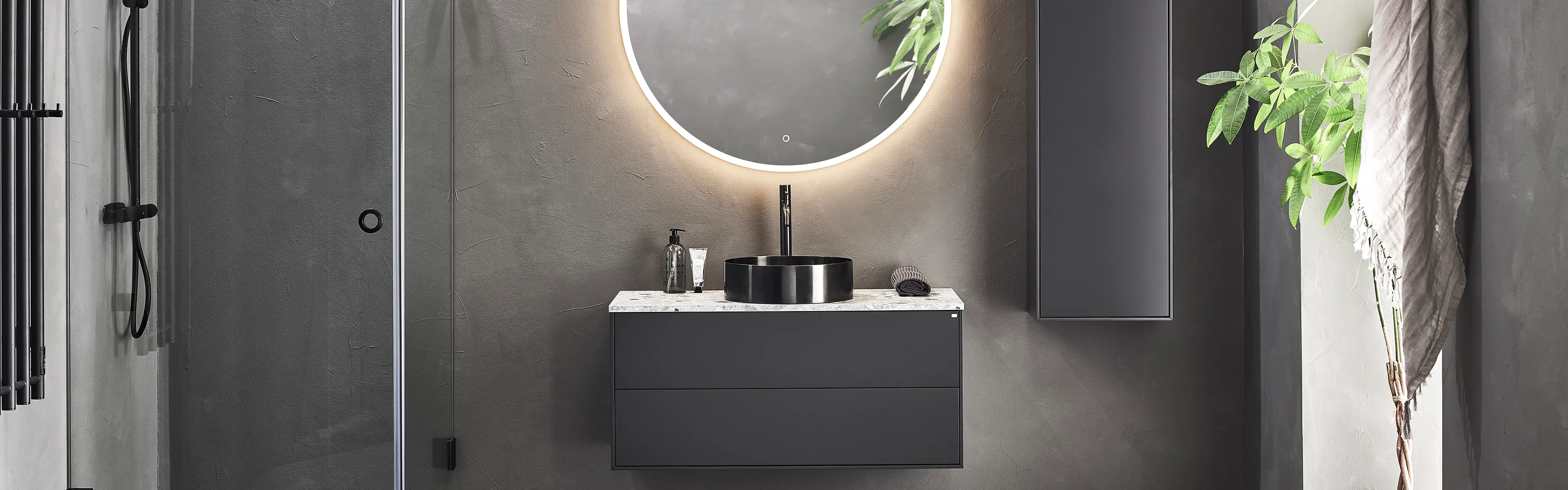 Baderom med mørkegrå møbler og sort servant