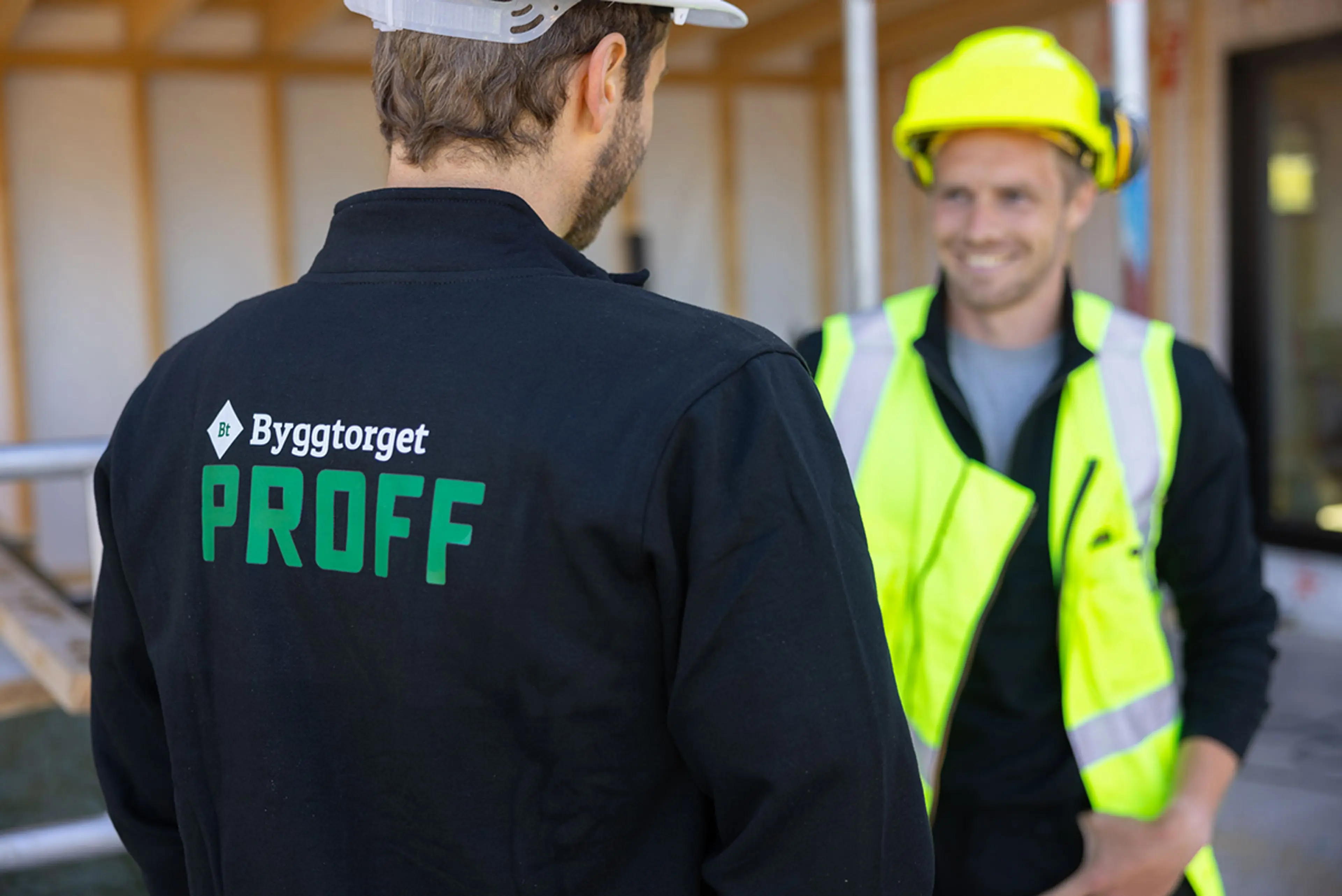 proffselger fra Byggtorget står med ryggen til og snakker til en håndverker