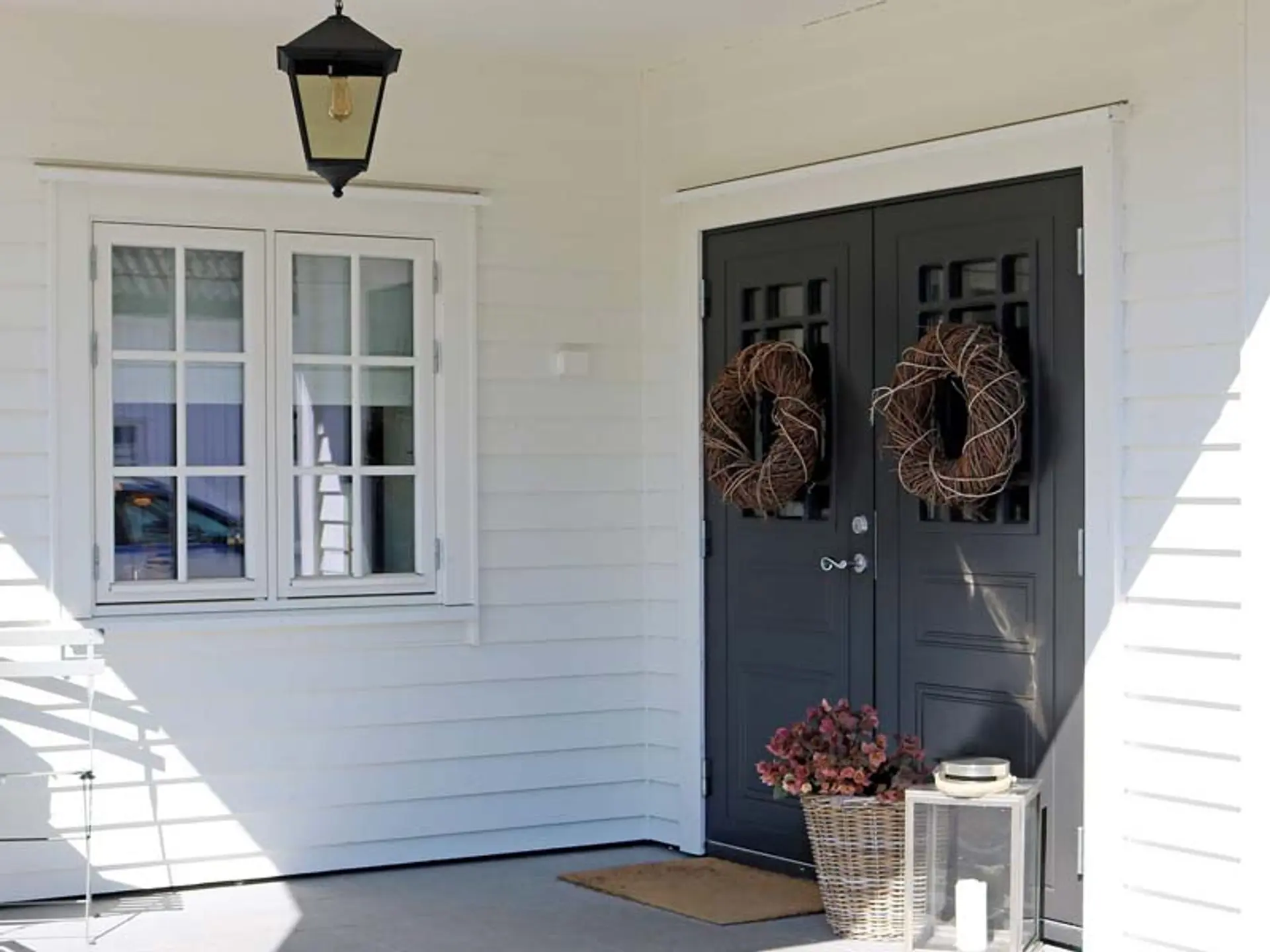 Hvitt hus med tofløyet svart ytterdør fra Harmonie