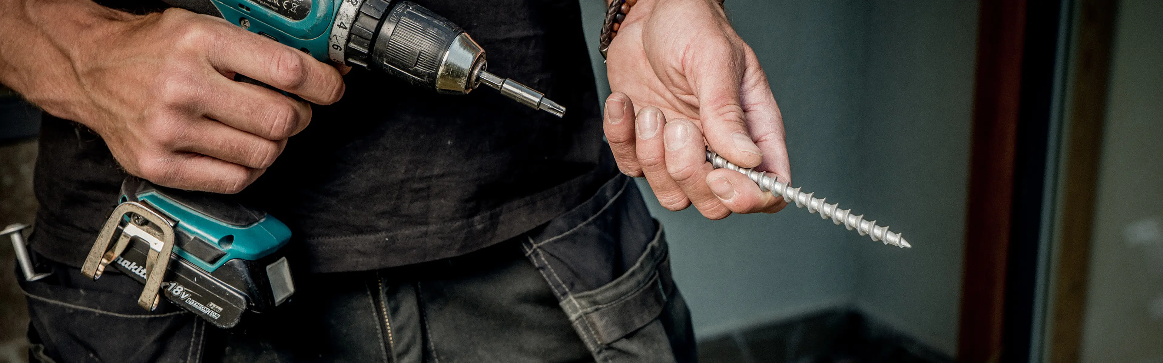 Mann holder en Makita drill og en betongskrue fra Essve