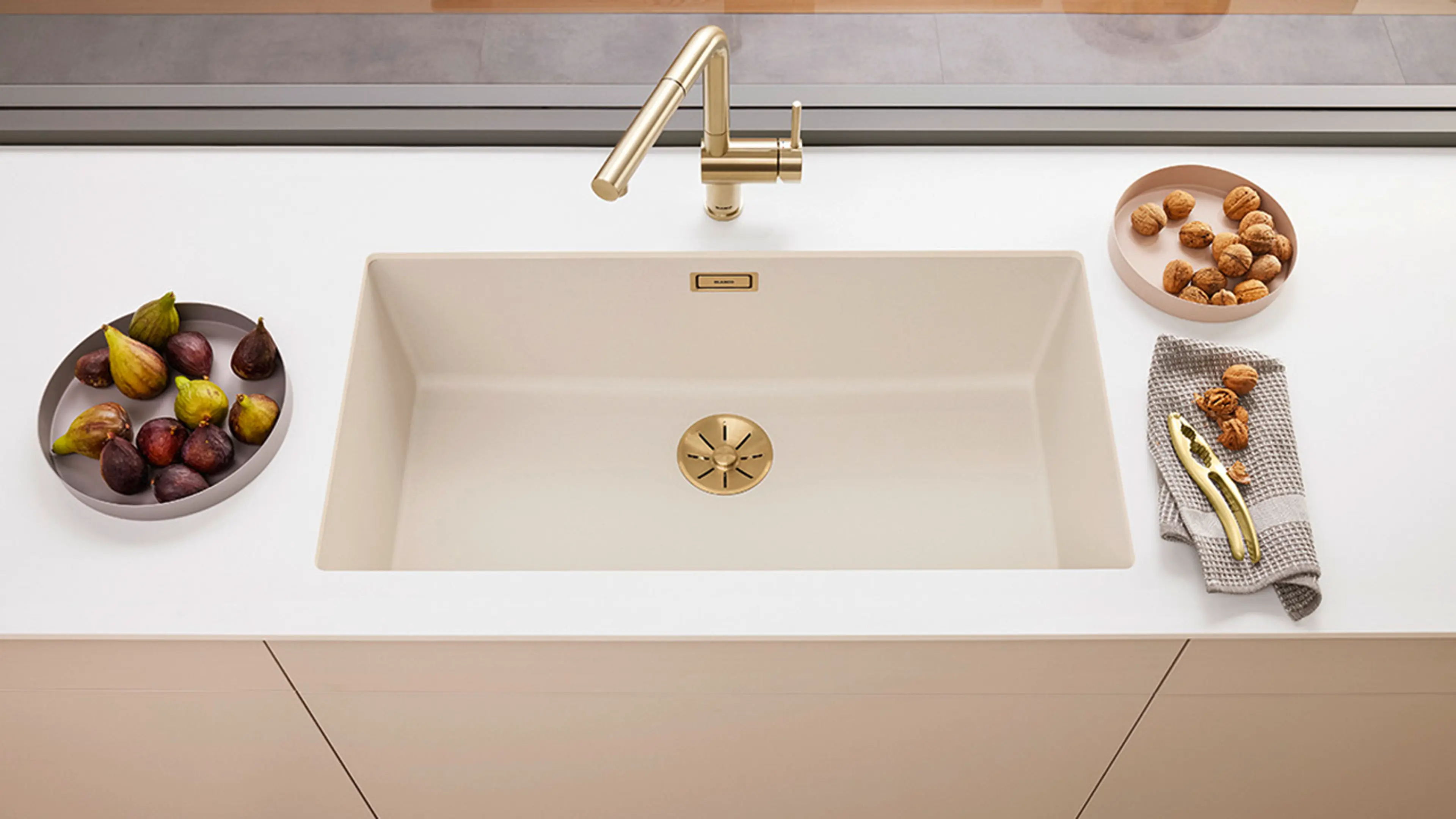 Blandebatteri i messing på kjøkken med lyse overflater.