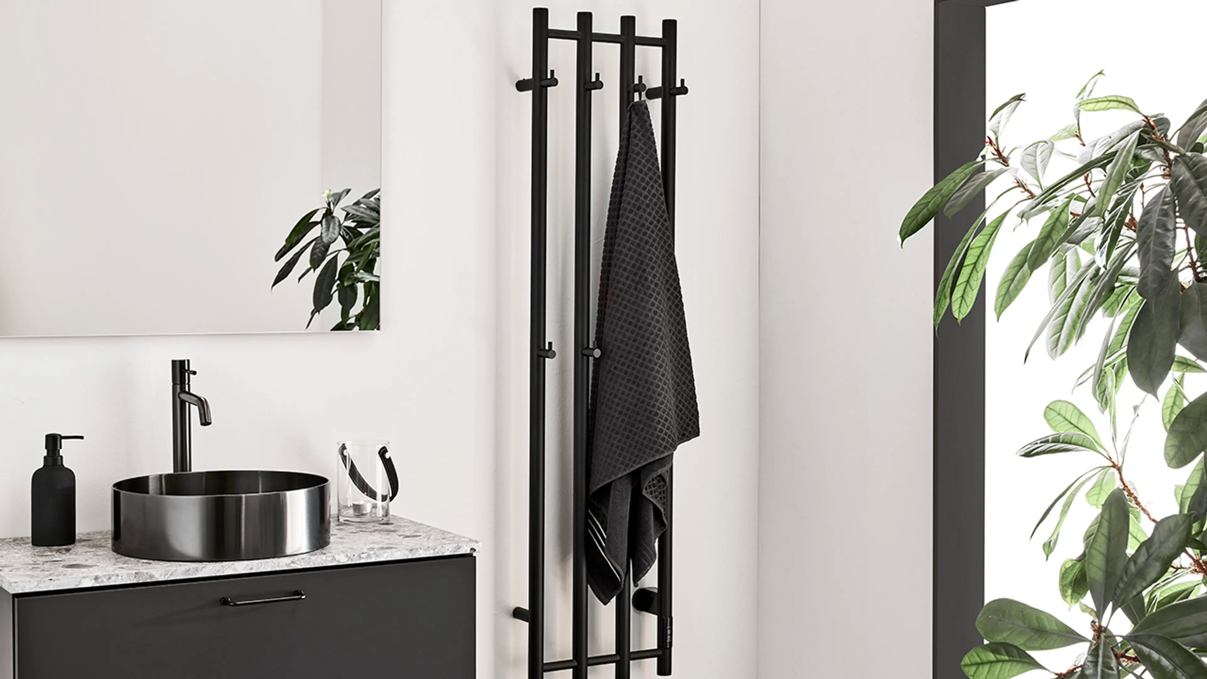 Sorte detaljer i krom på lyst bad.