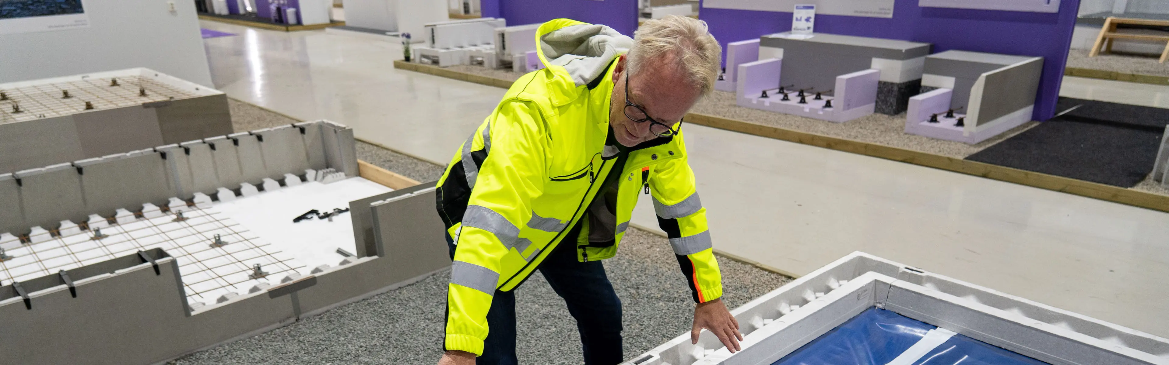 mann i gul jakke peker på et spor der radonsikring skal legges inn i Jackon Ringmur RA