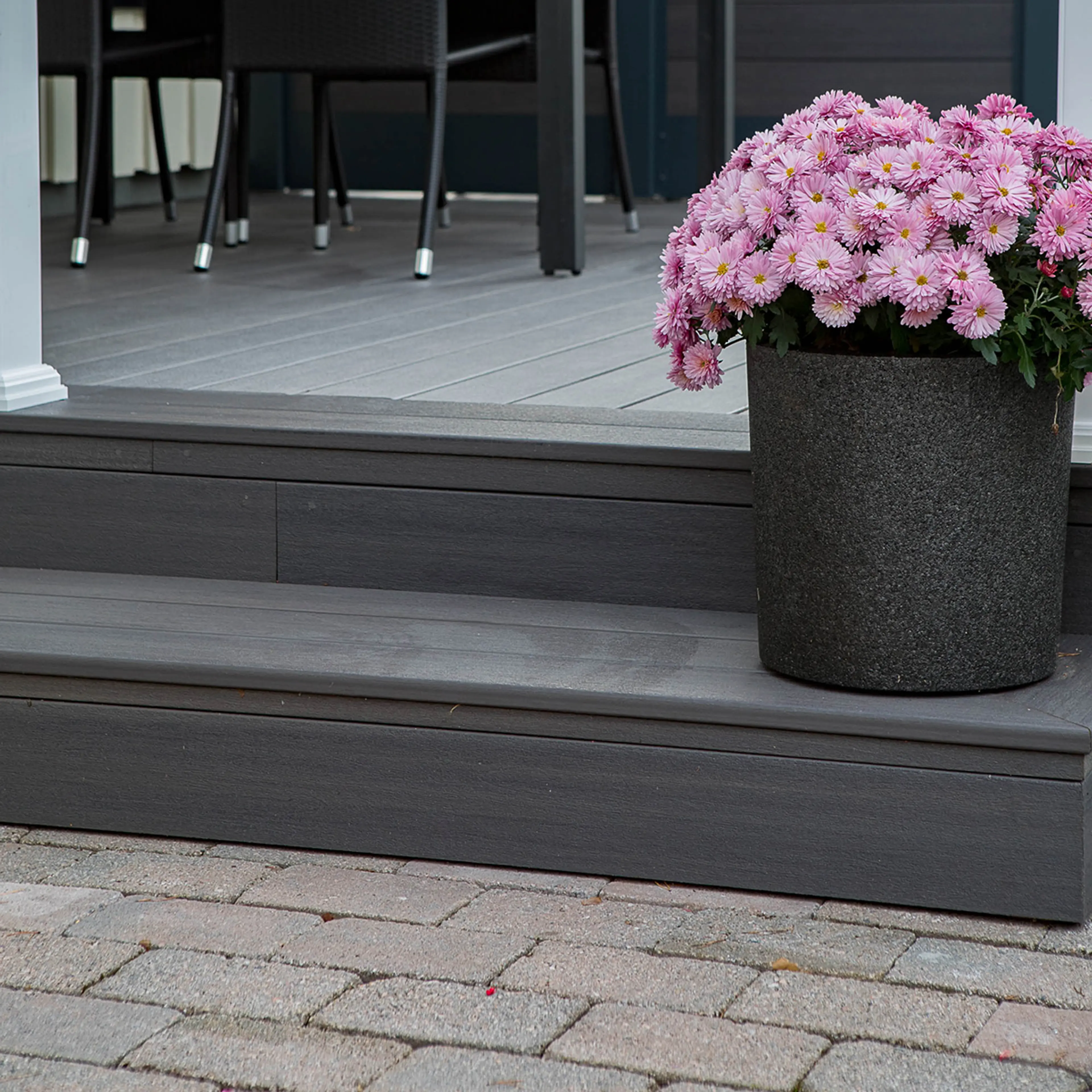 Trapp til terrasse og bomsterpotte med rosa blomster. Inspirasjon