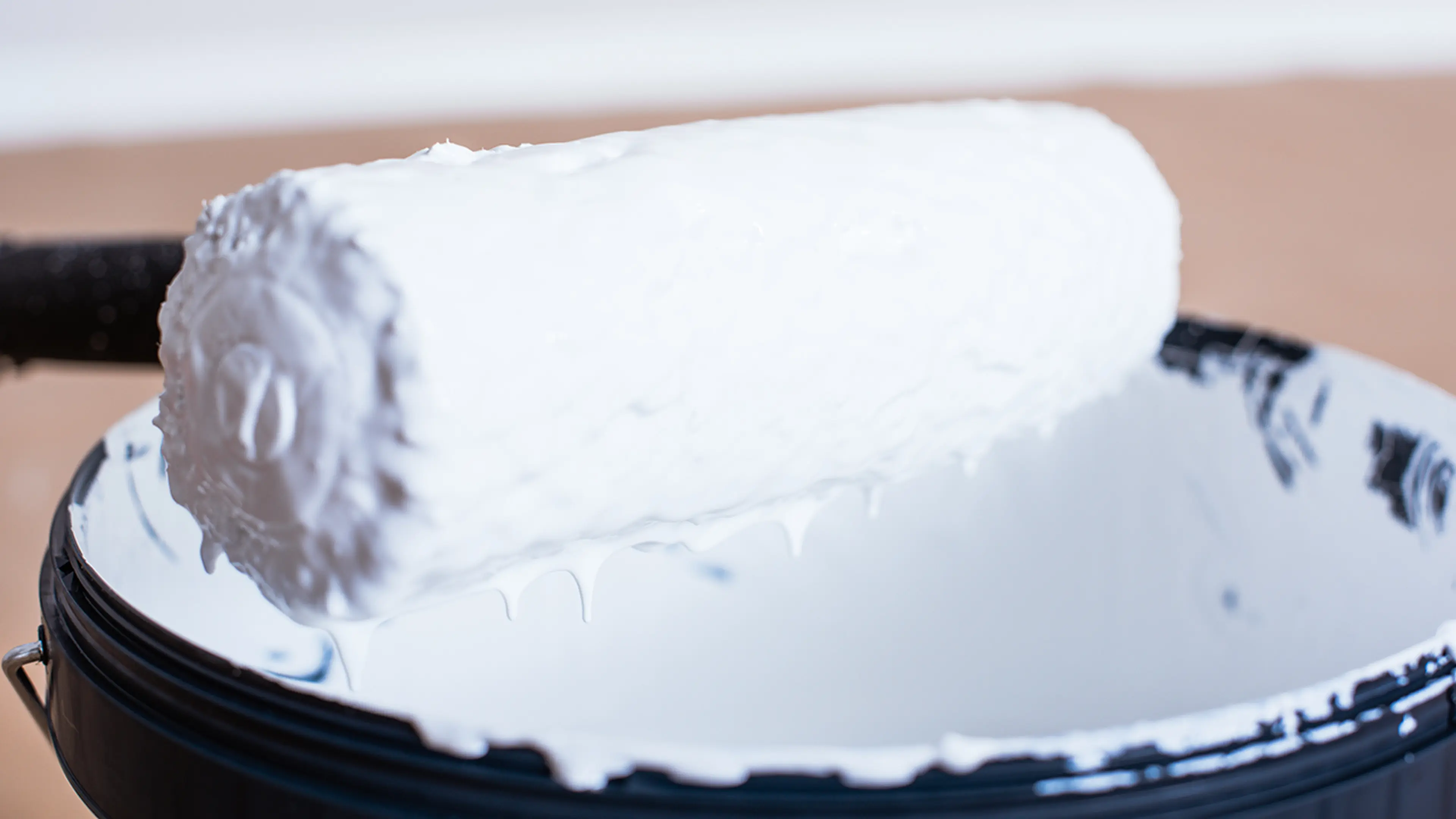 Hvitmaling på rulle. Nok maling på malerullen er viktig når du skal male gulvet.