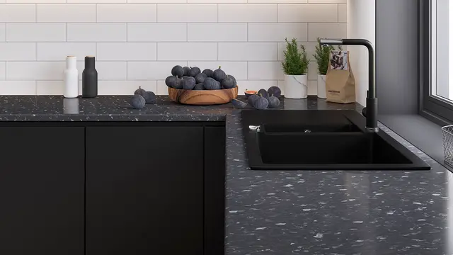 Svart kjøkken med svart terrazzo benkeplate.