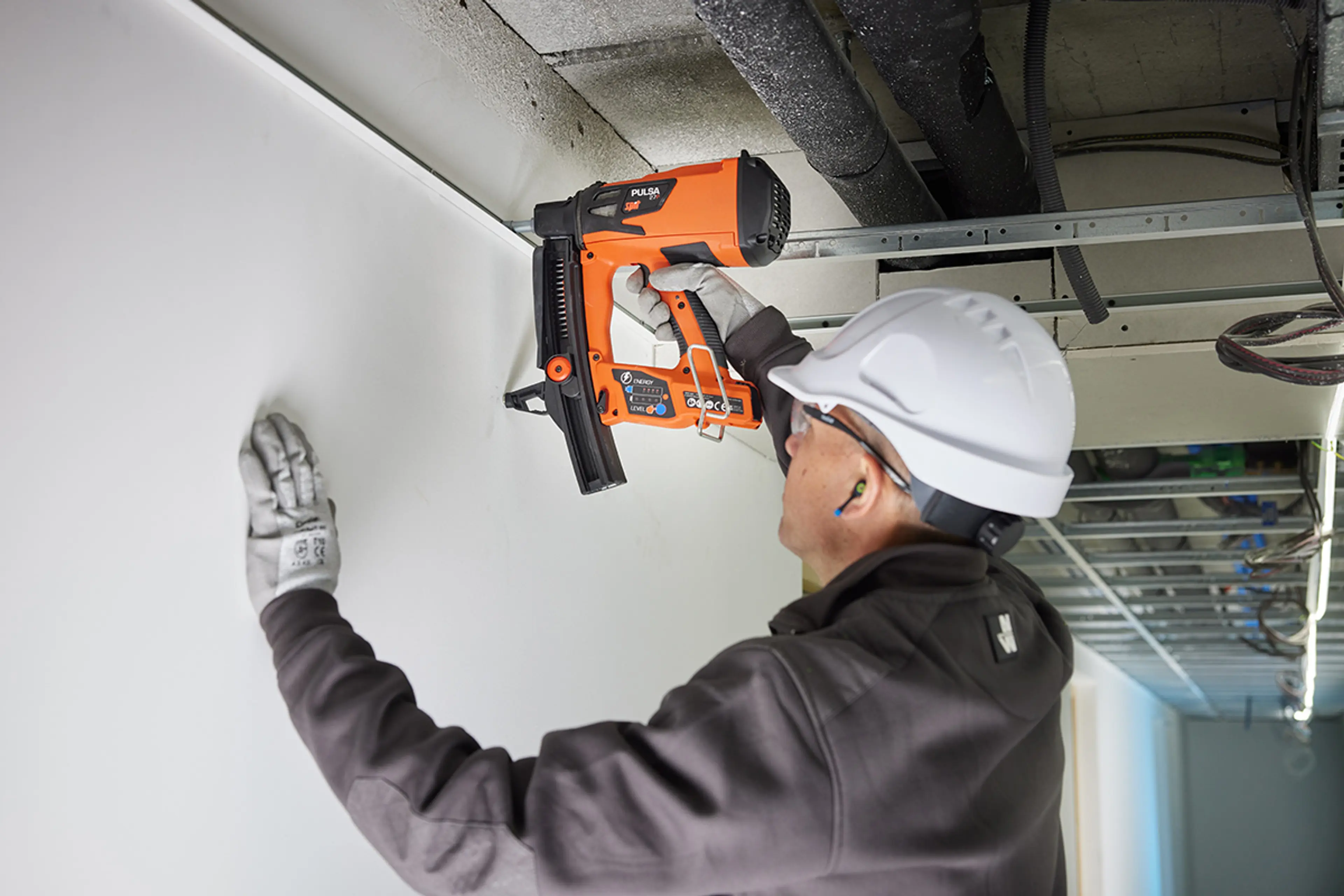 Mann fester i betong med en boltemaskin