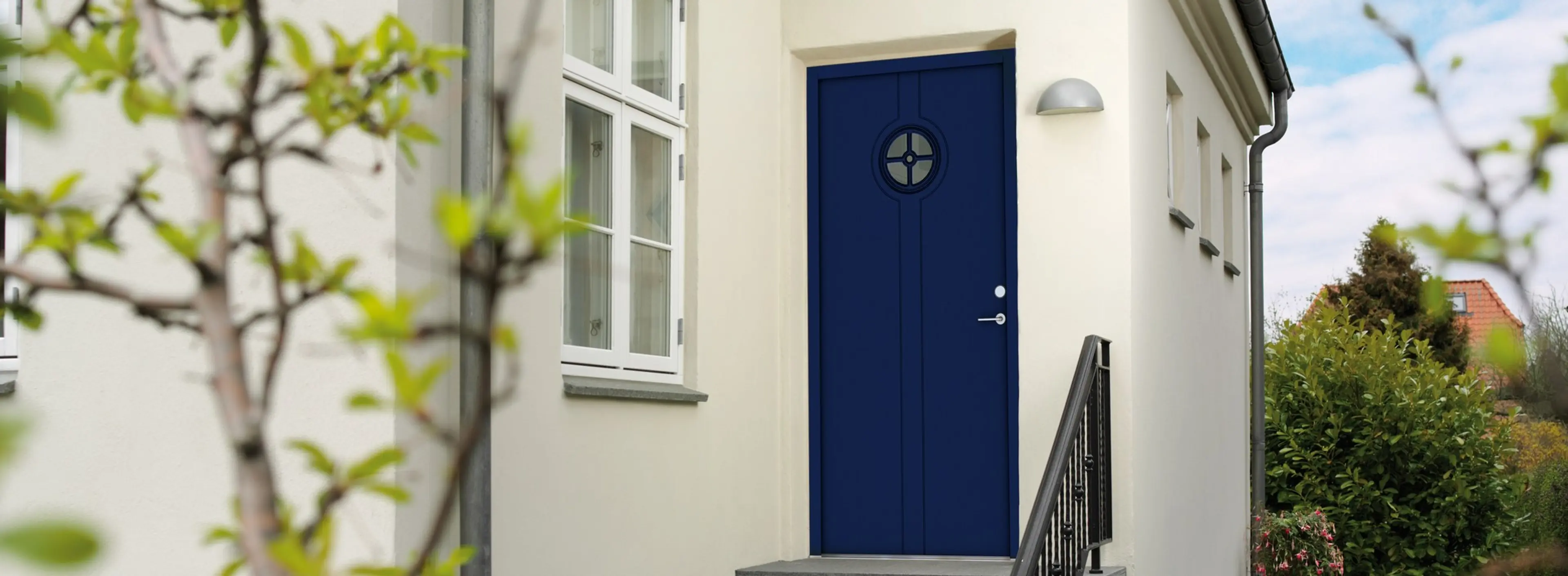 blå ytterdør på hvitt murhus