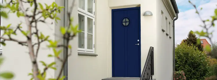 blå ytterdør på hvitt murhus