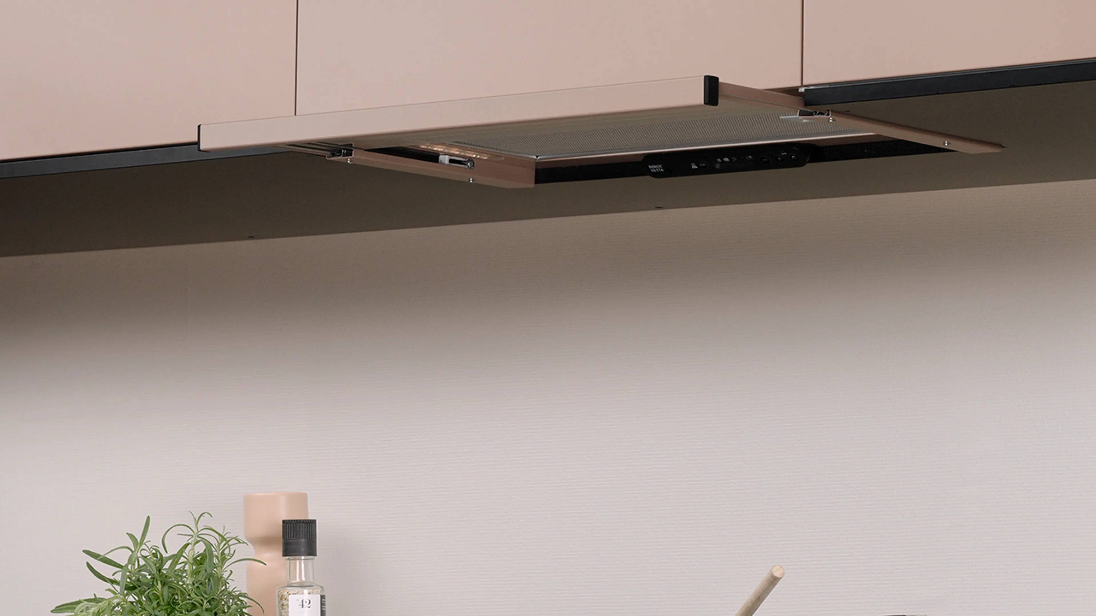 Kjøkkenvifte med uttrekk i ferskenfarget kjøkken.