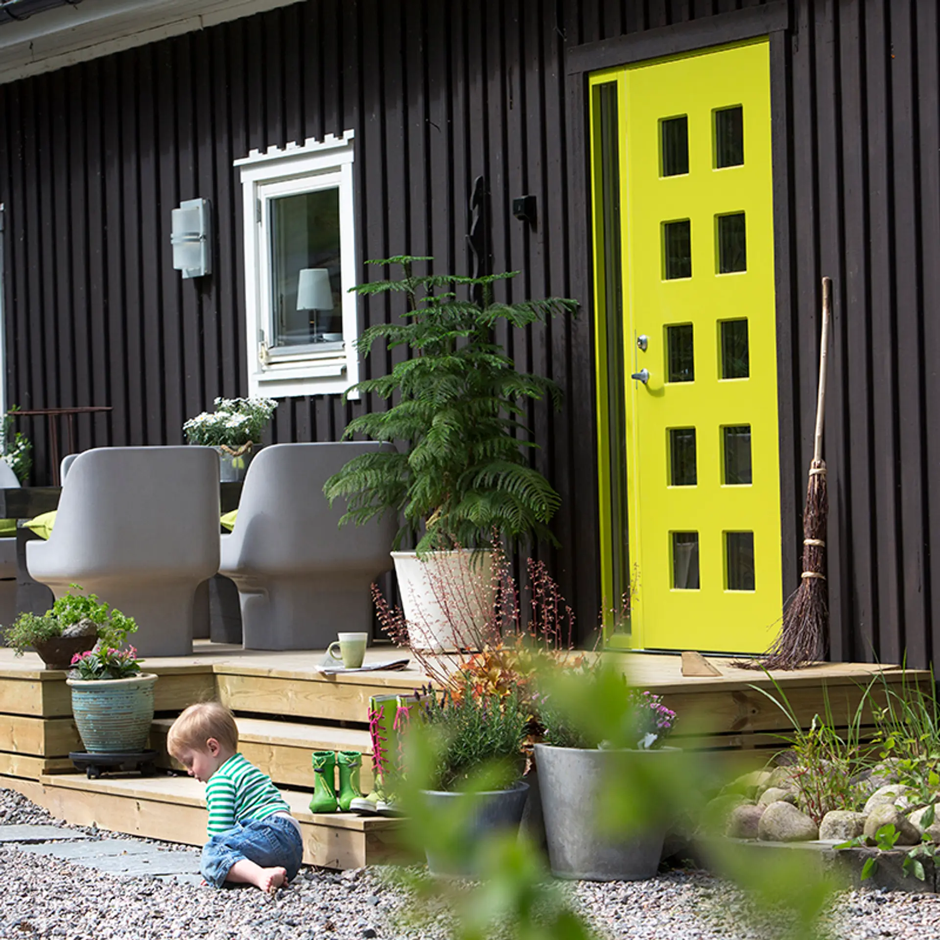 Svart hus med limegrønn ytterdør fra Swedoor