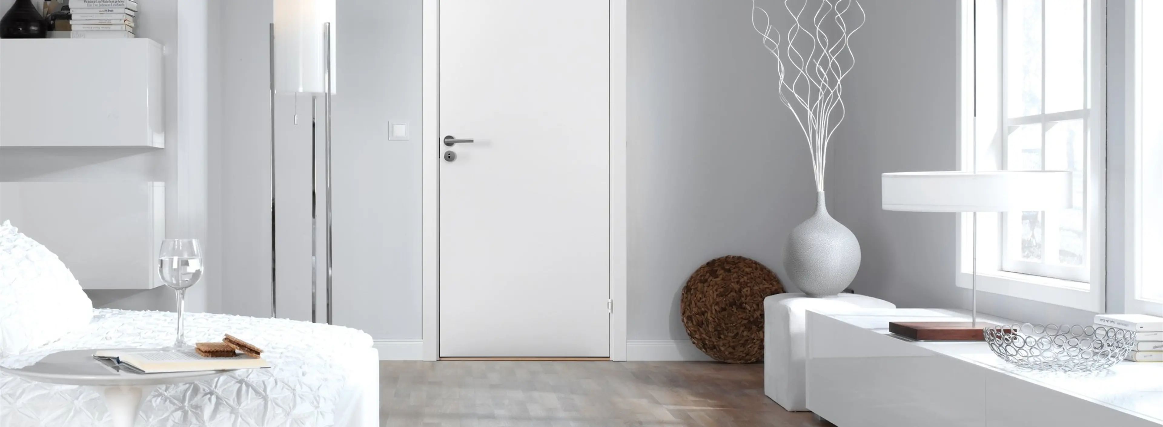 Moderne rom med hvitt interiør og grå dører.