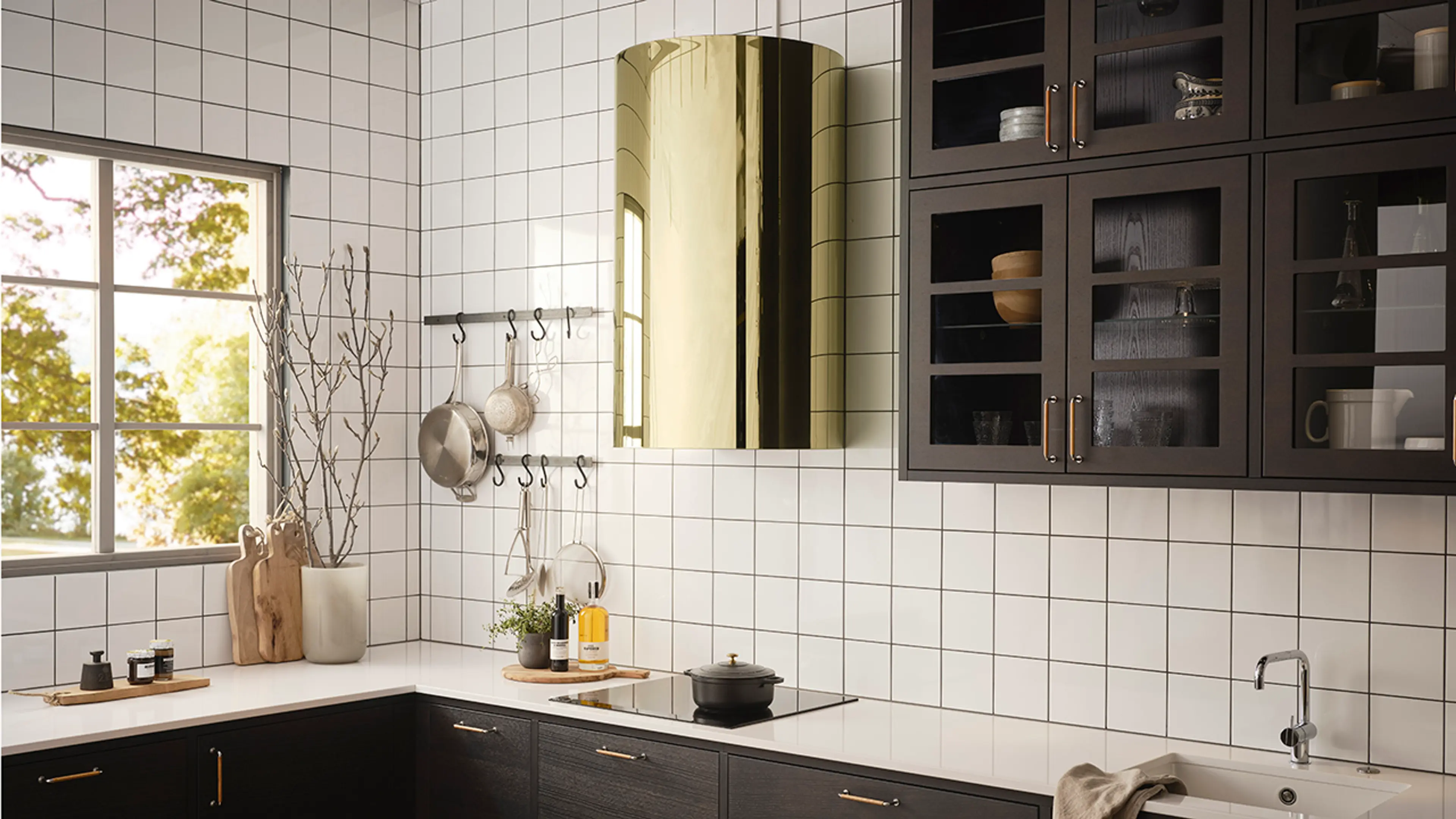 Kjøkkenhette i messing fra RørosHetta på hvitt og brunt kjøkken.