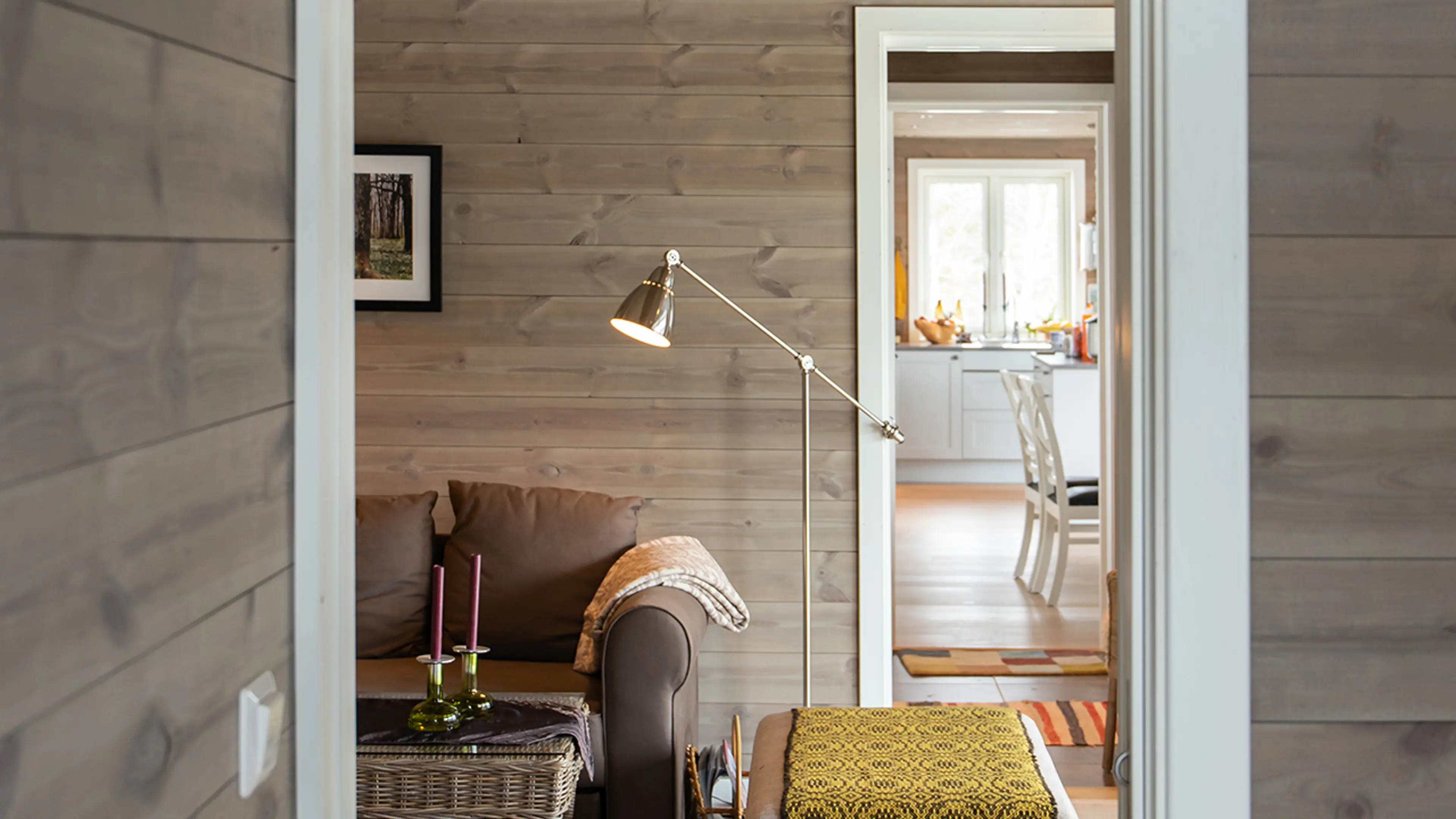 Klassisk hytte med trepanel på veggene og hvite lister.