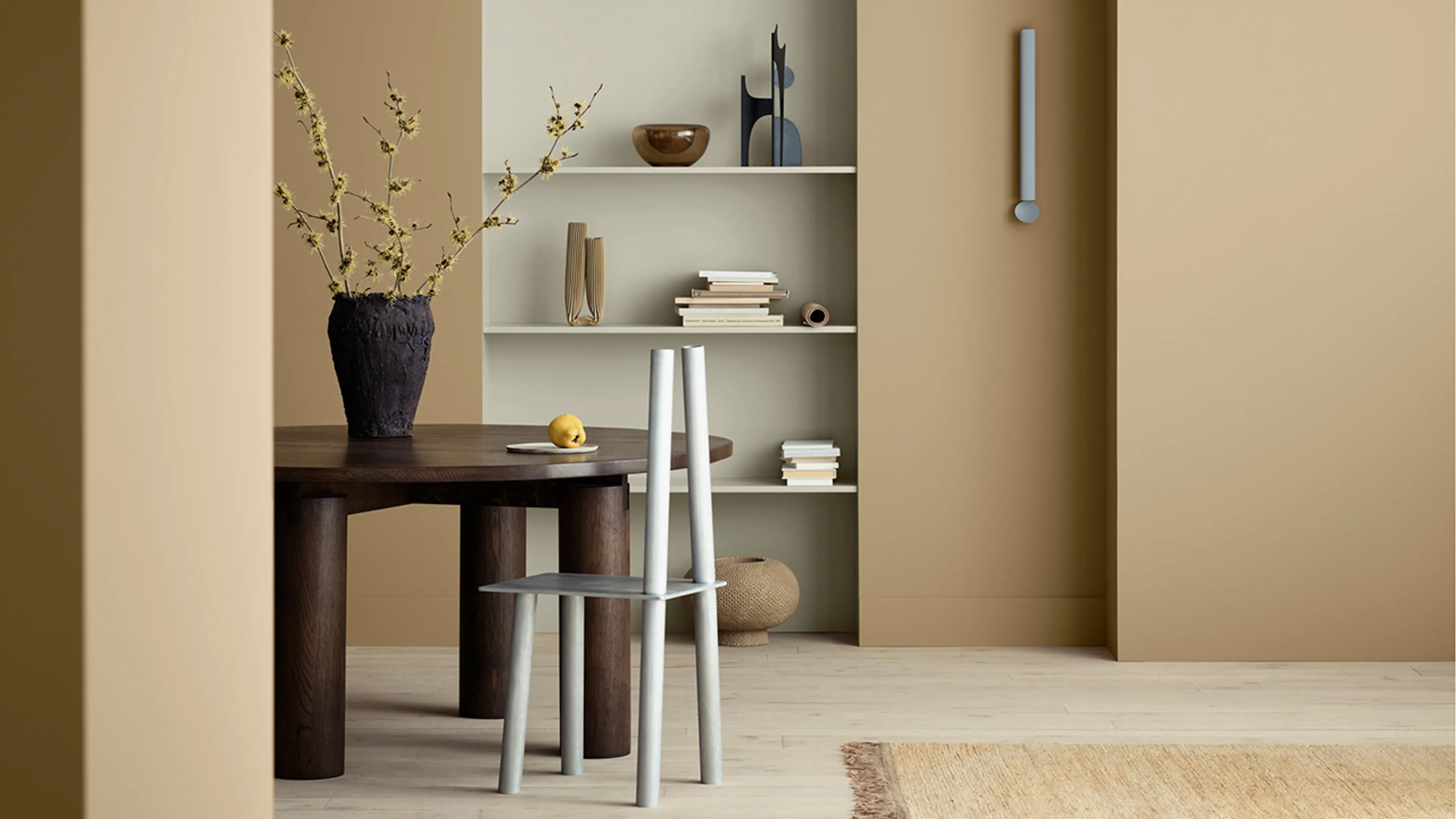 Oppholdsrom med åpen hylle hvor hylleveggen er malt med 12075 Soothing Beige og vegger i fargen 1632 Rock Sugar fra Jotuns nye fargekart CANVAS.