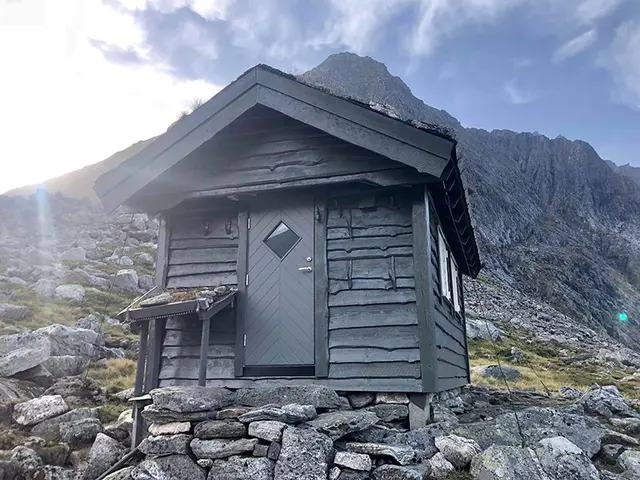 liten fjellstue med grå ytterdør