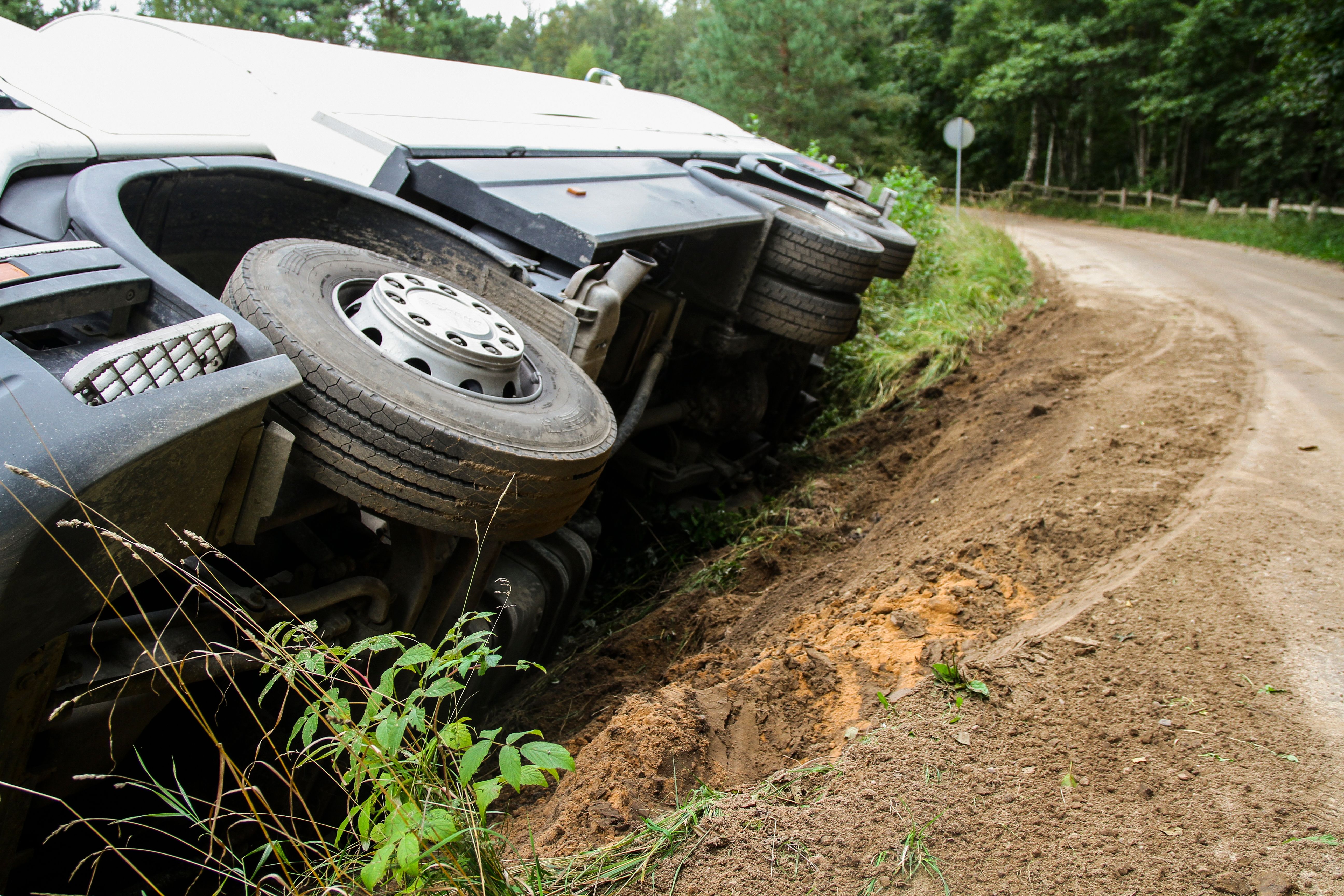 HGV lying on it's side next to a street after an accident.