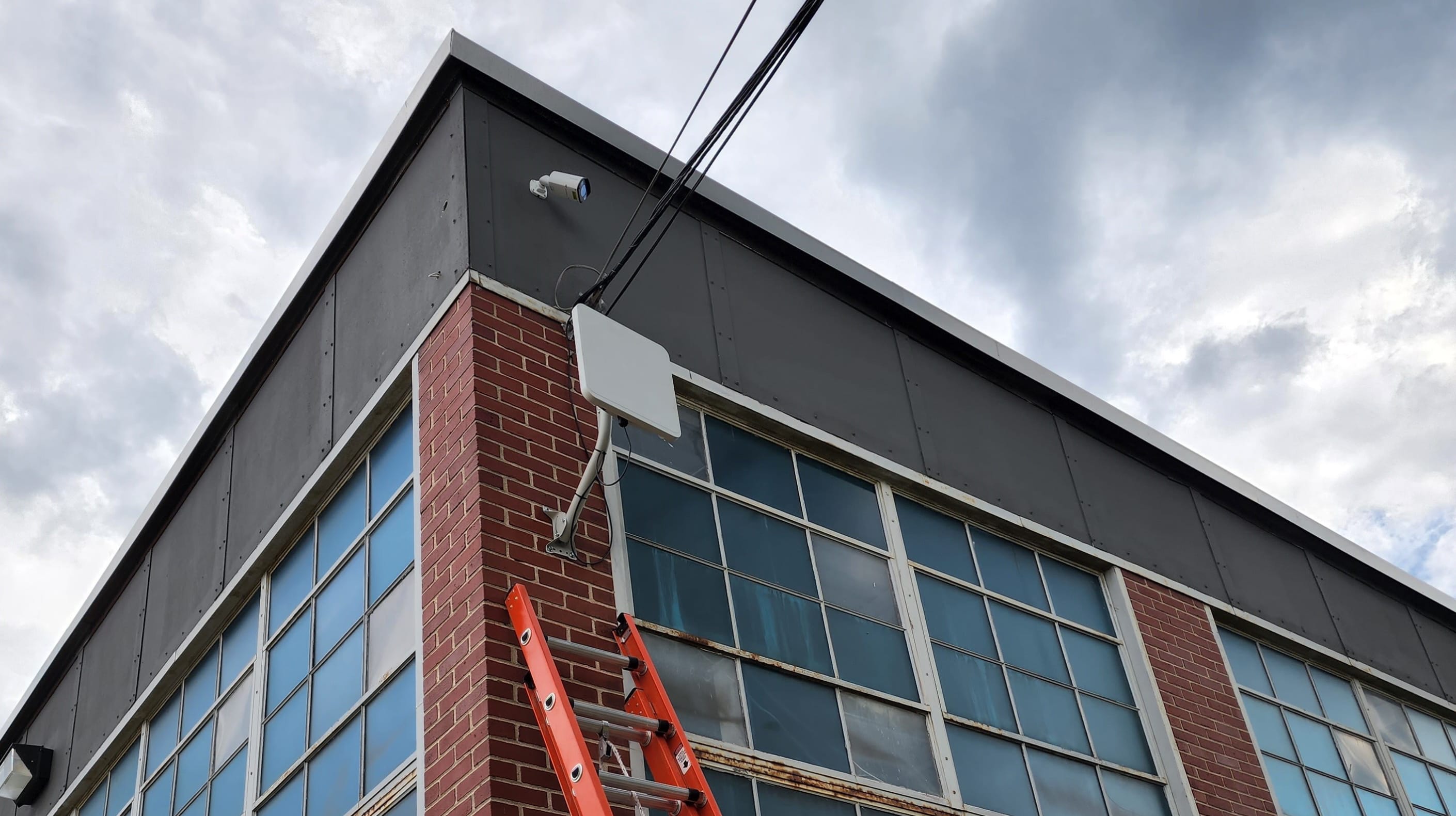 A cellular antenna mounted up against the side of a building.