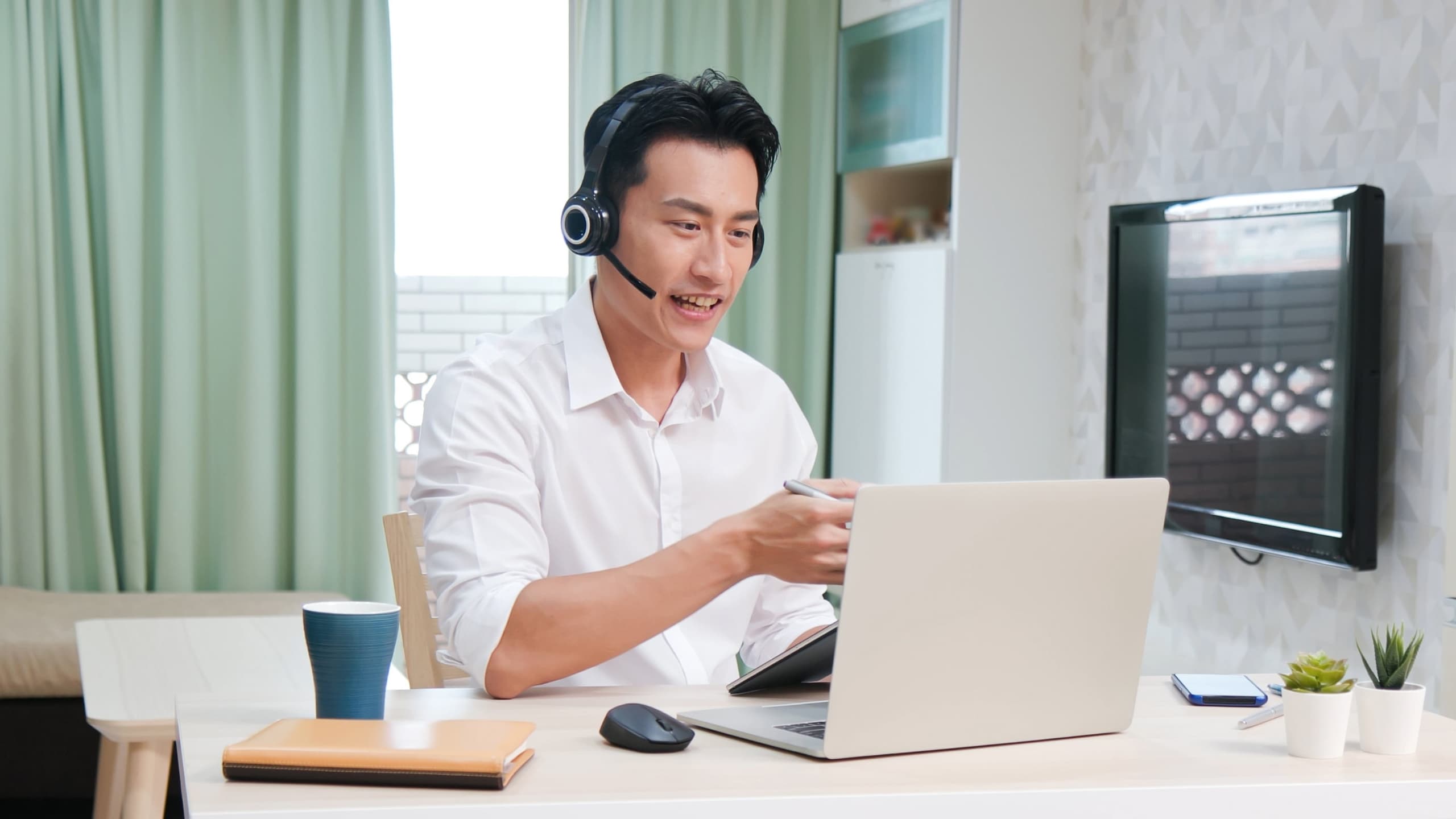 A person having a meeting while working from home on their laptop.