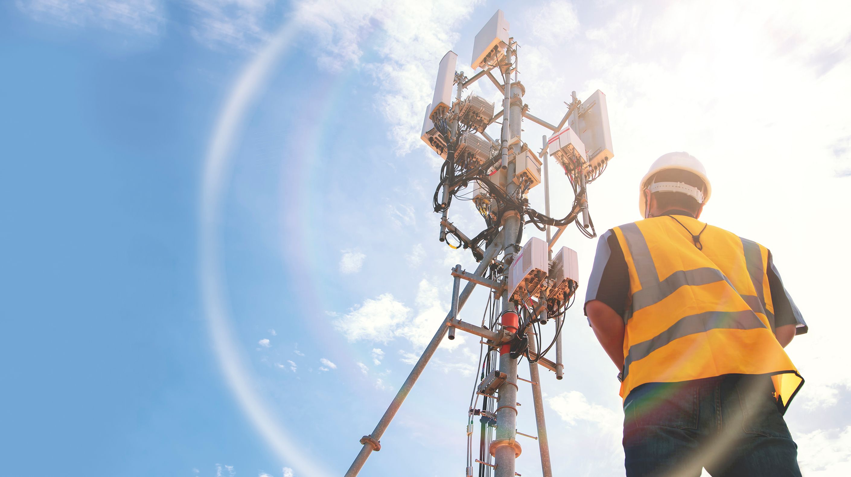 Worker studying a 5G tower.