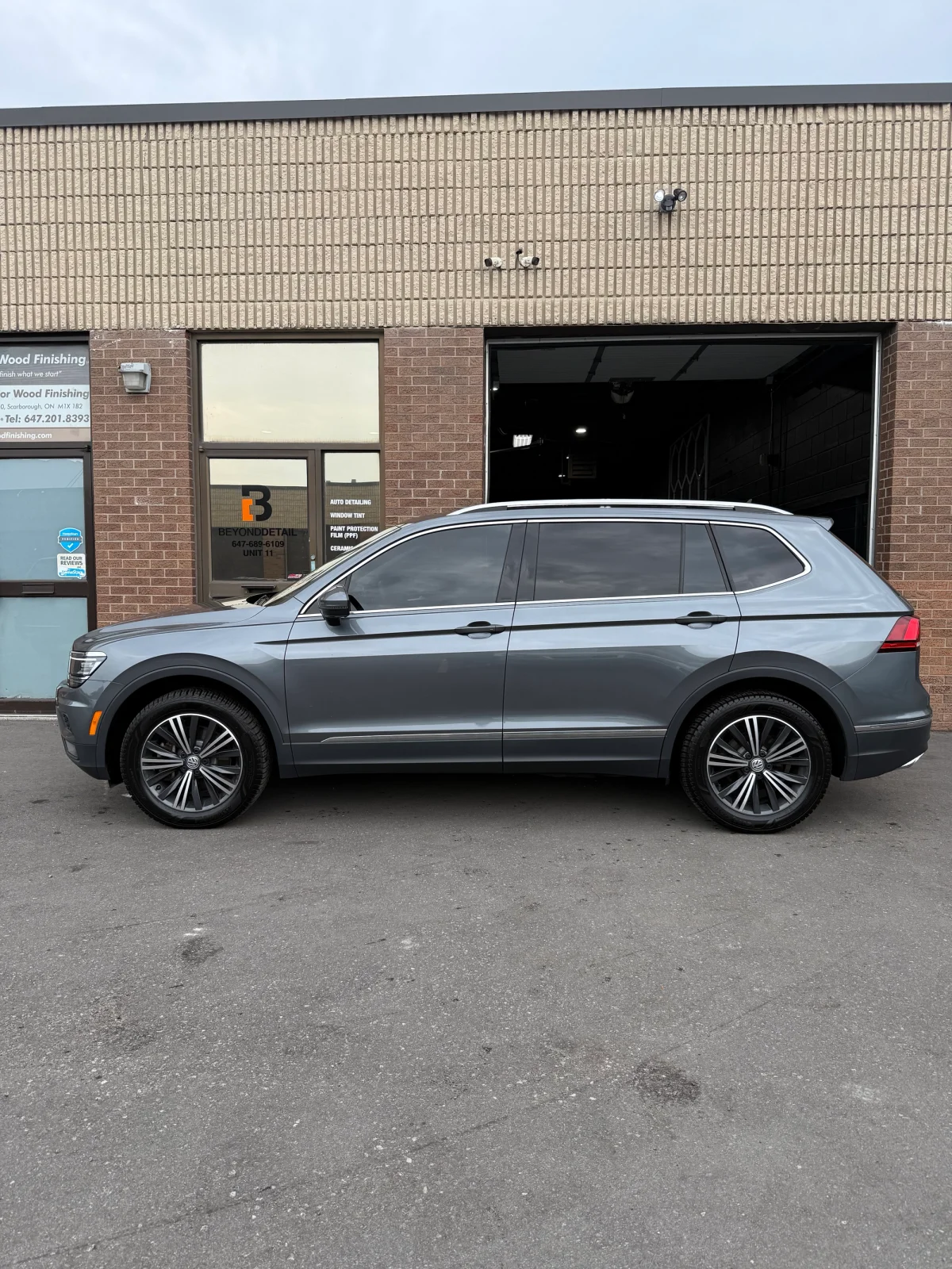 Technician installing window tint using a squeegee during a professional car tint application at Beyond Detail Scarborough.