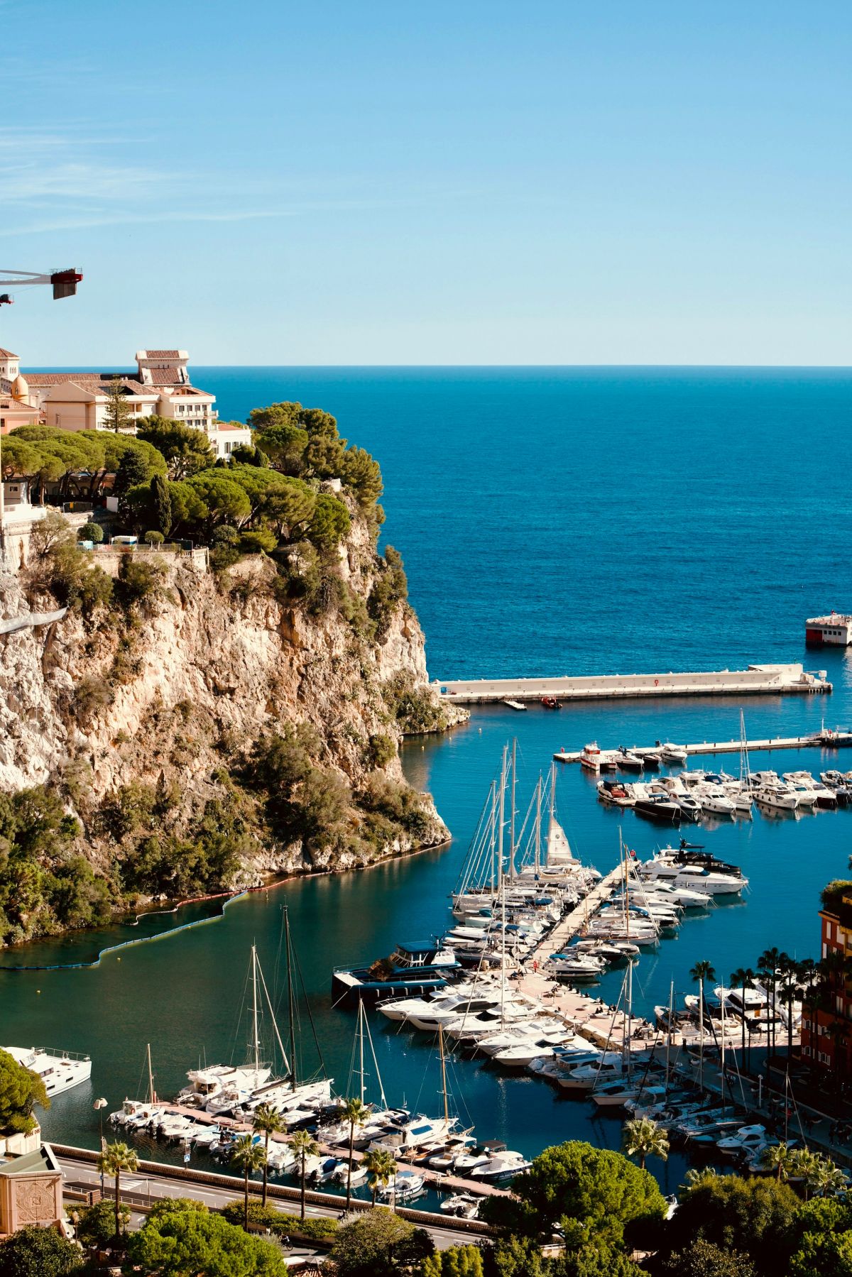 A sunny harbour beneath cliffside buildings