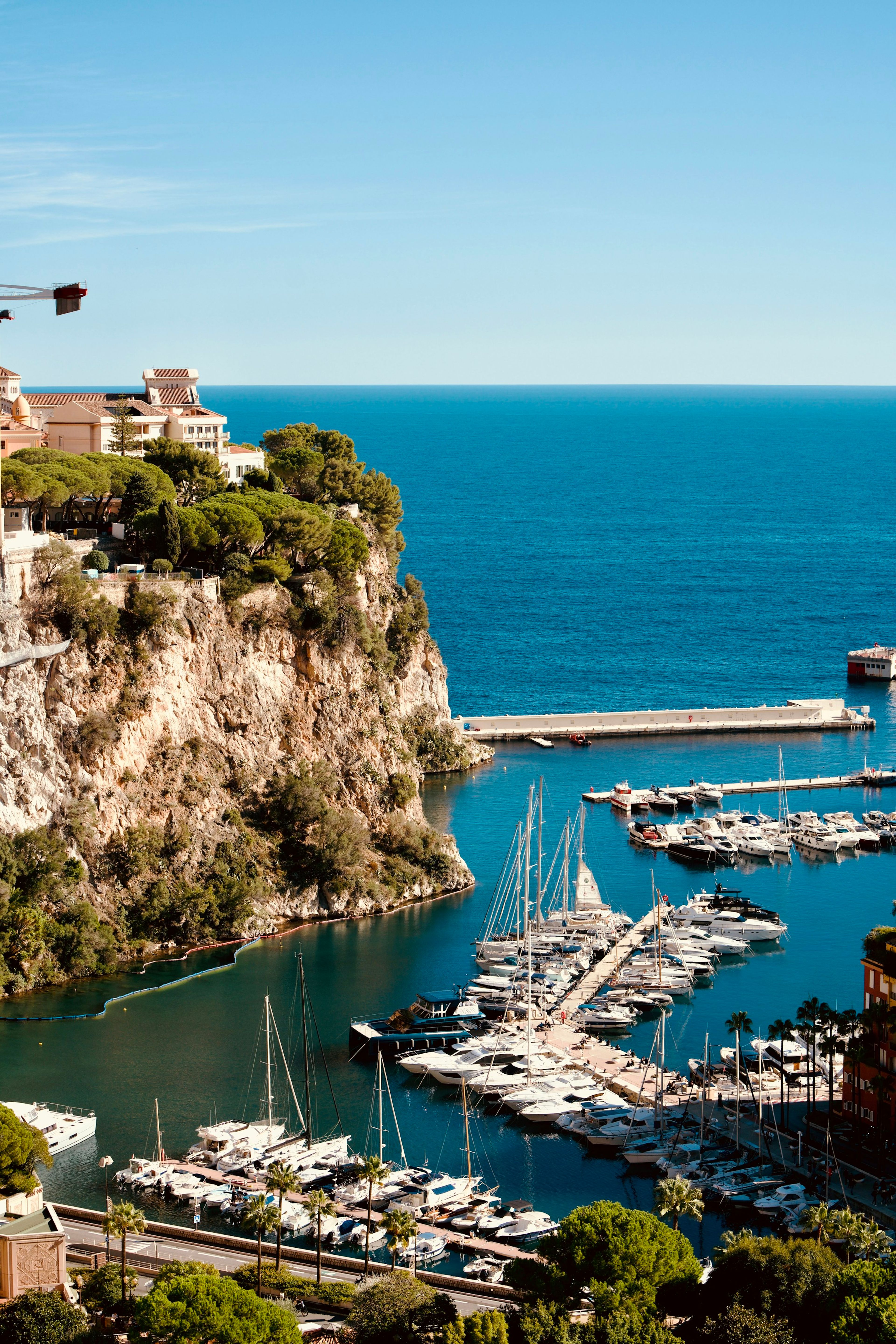 A sunny harbour beneath cliffside buildings