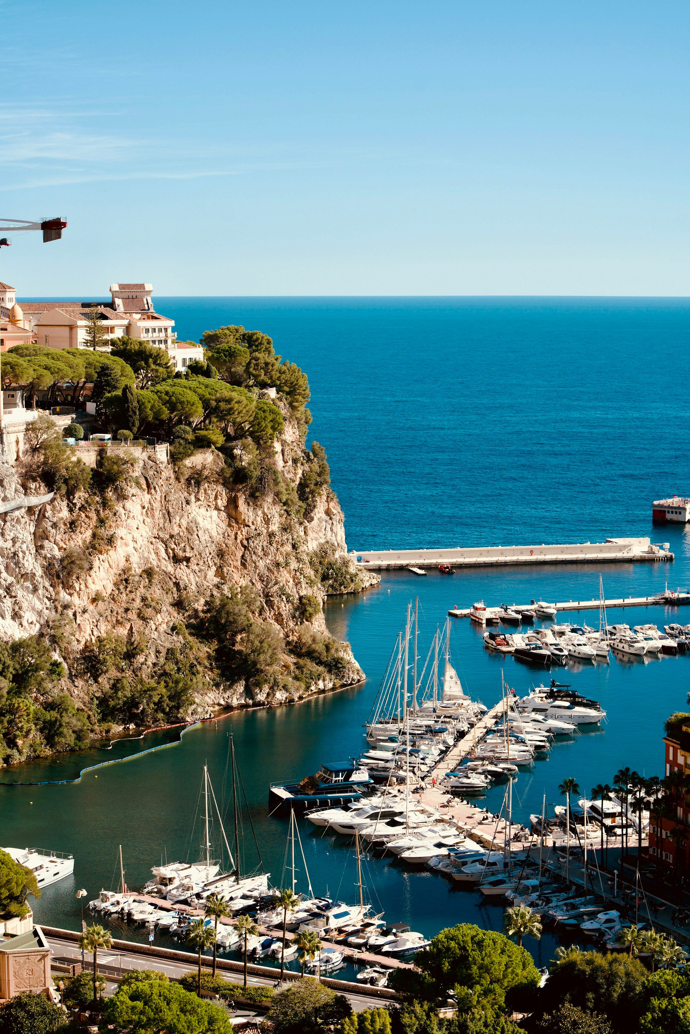 A sunny harbour beneath cliffside buildings