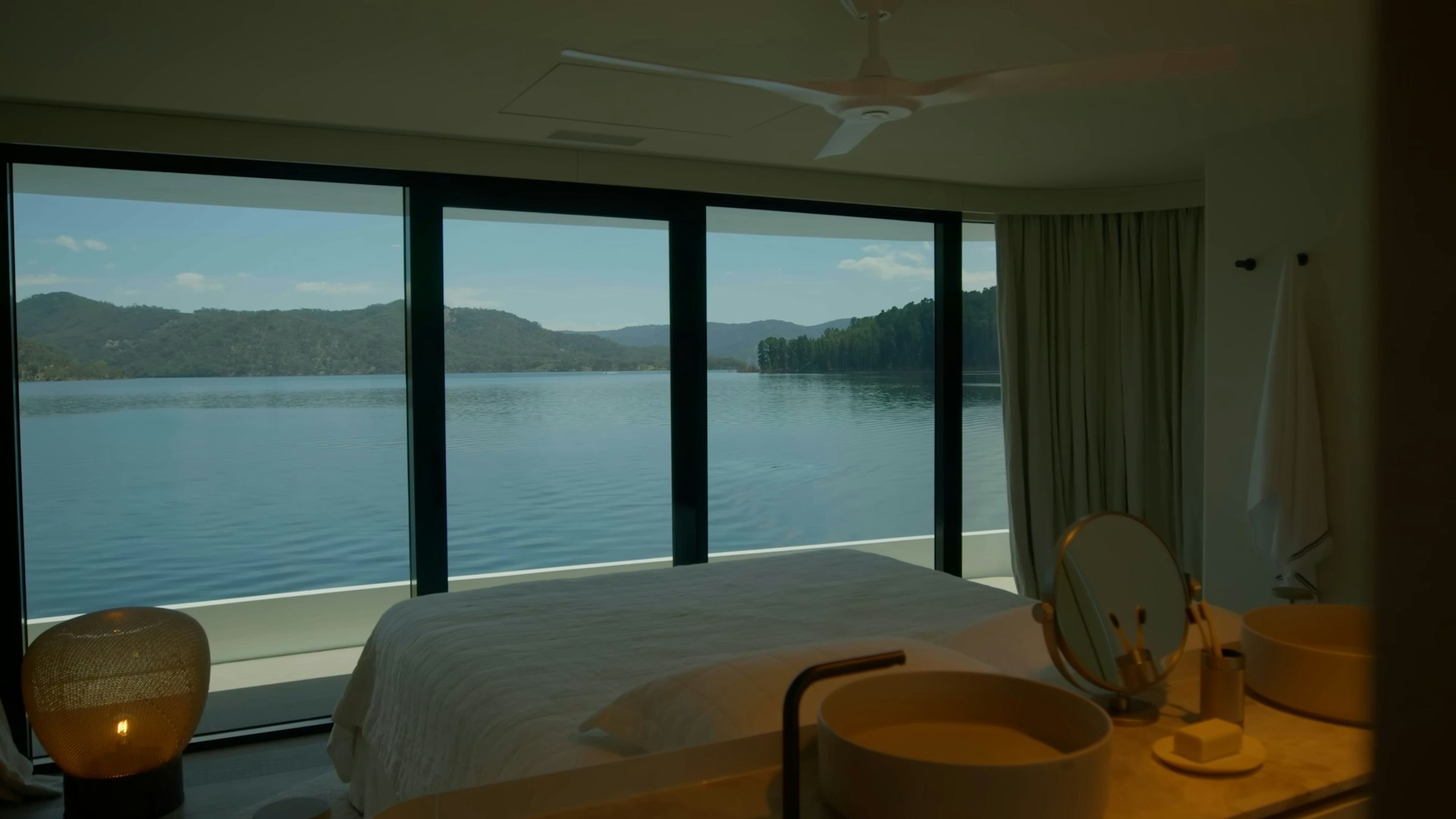 The master suite with full-height windows to the water