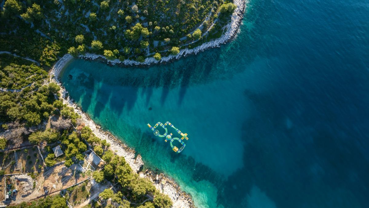 A boat crossing clear Adriatic water from above