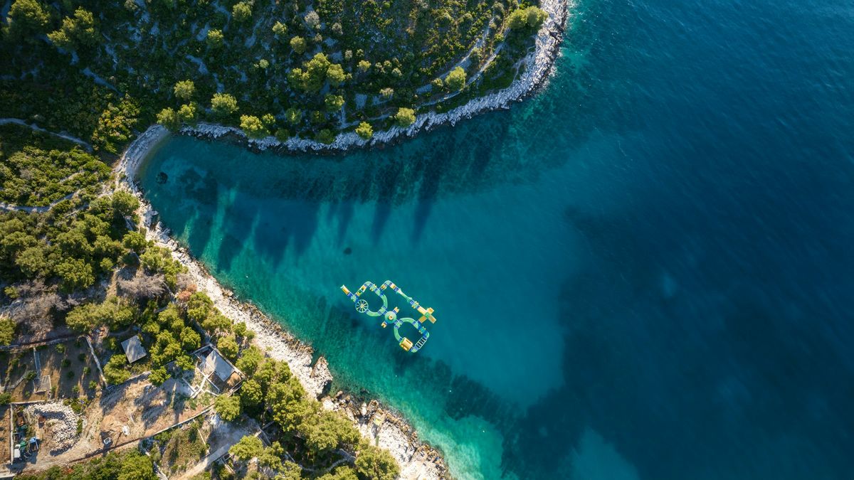 A boat crossing clear Adriatic water from above