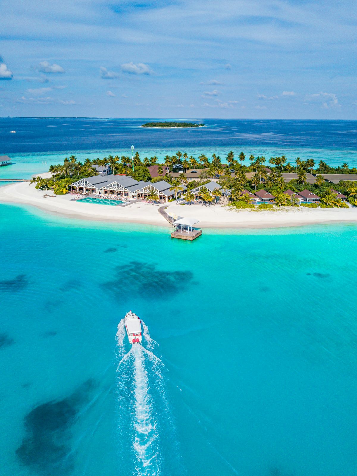 A boat heading towards a tropical island resort