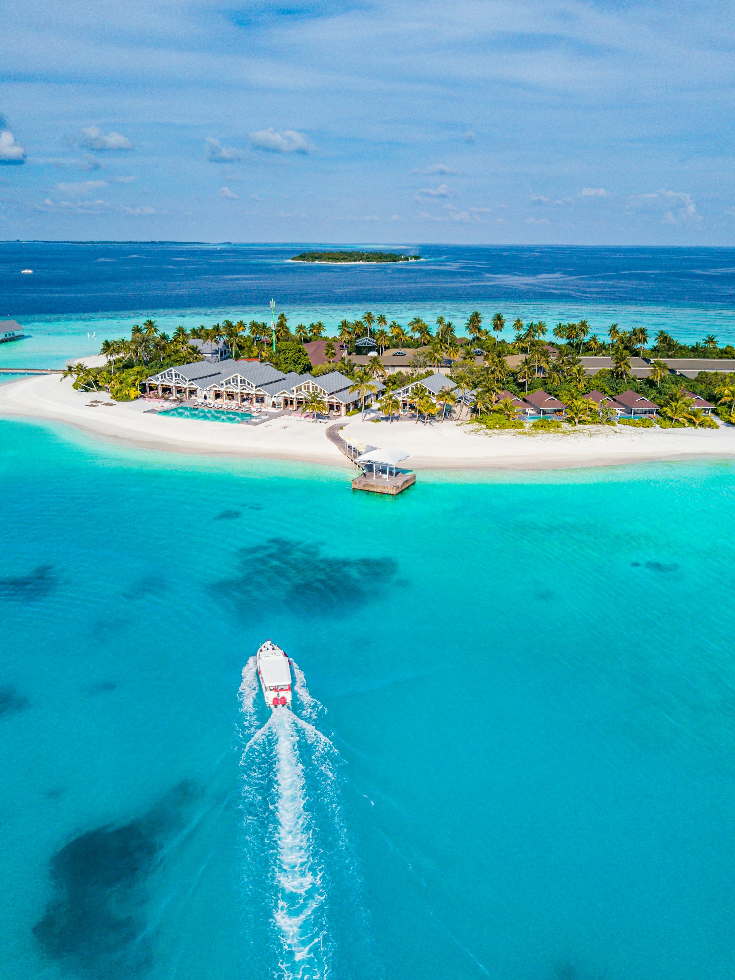 A boat heading towards a tropical island resort