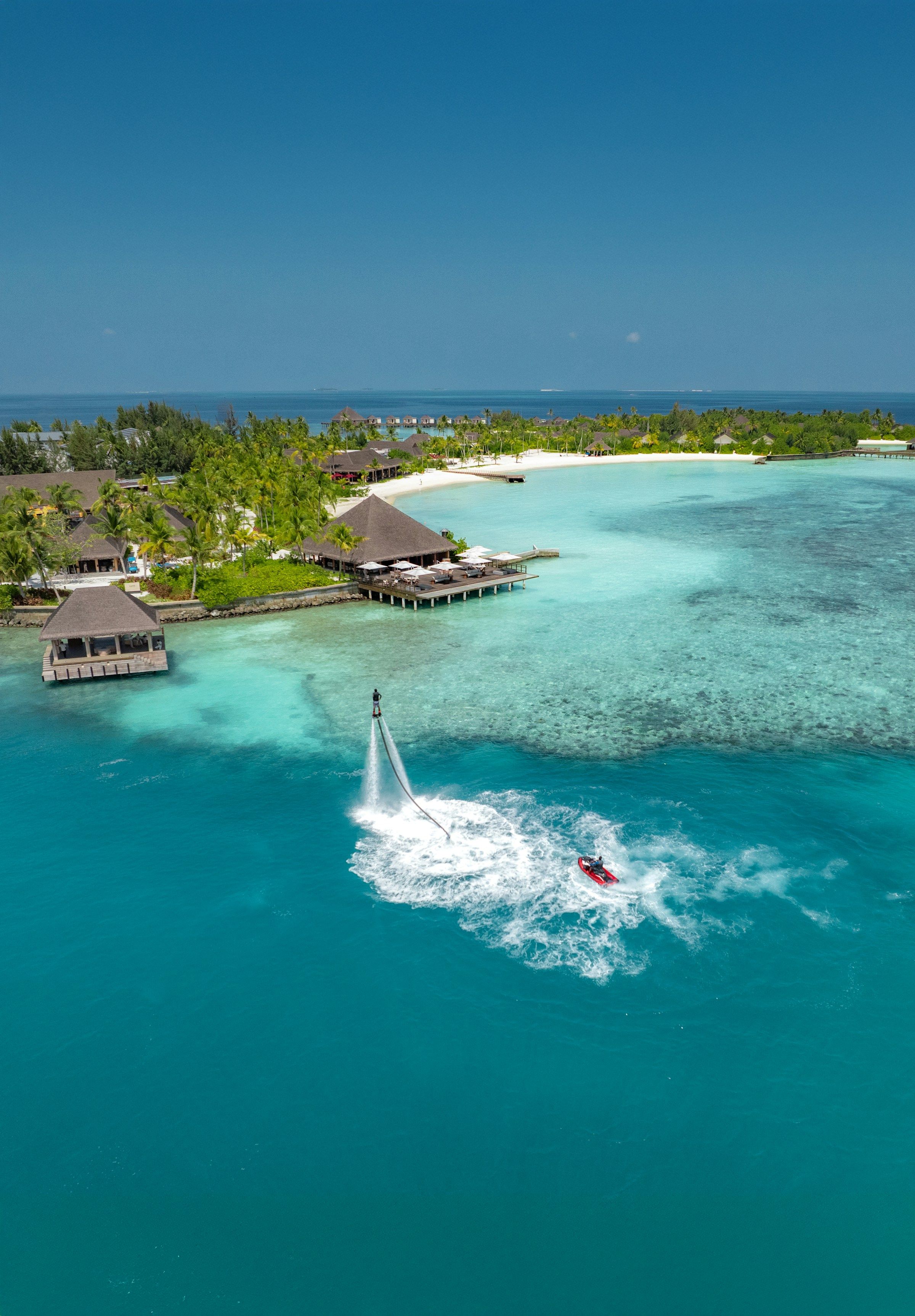 A person flyboarding above turquoise water