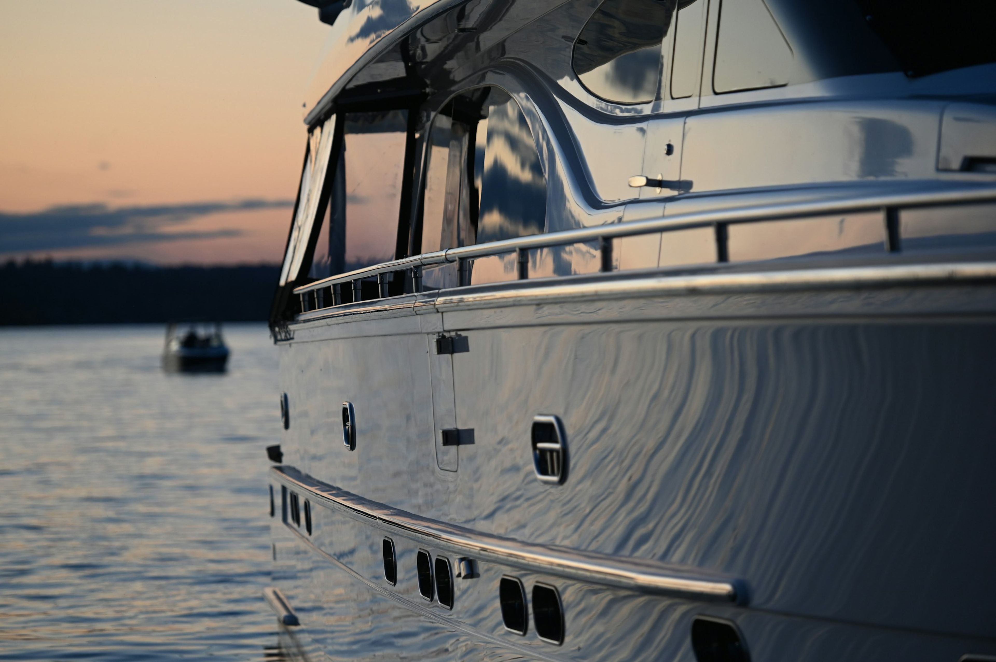 The curving hull of a yacht at dusk