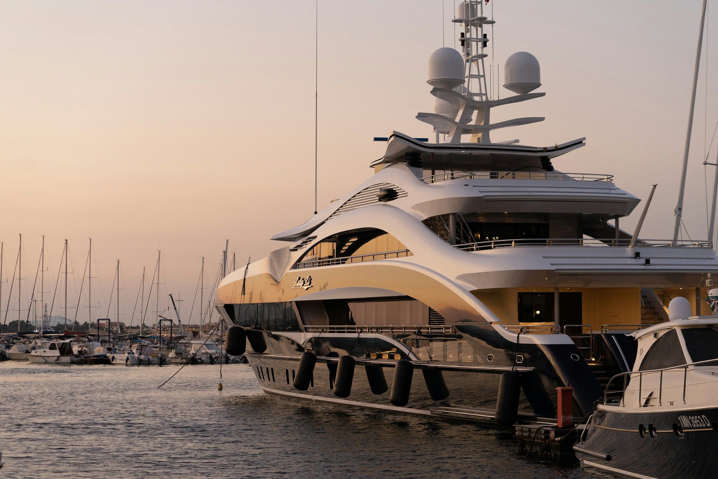 Marisol in a marina at sunset with masts behind