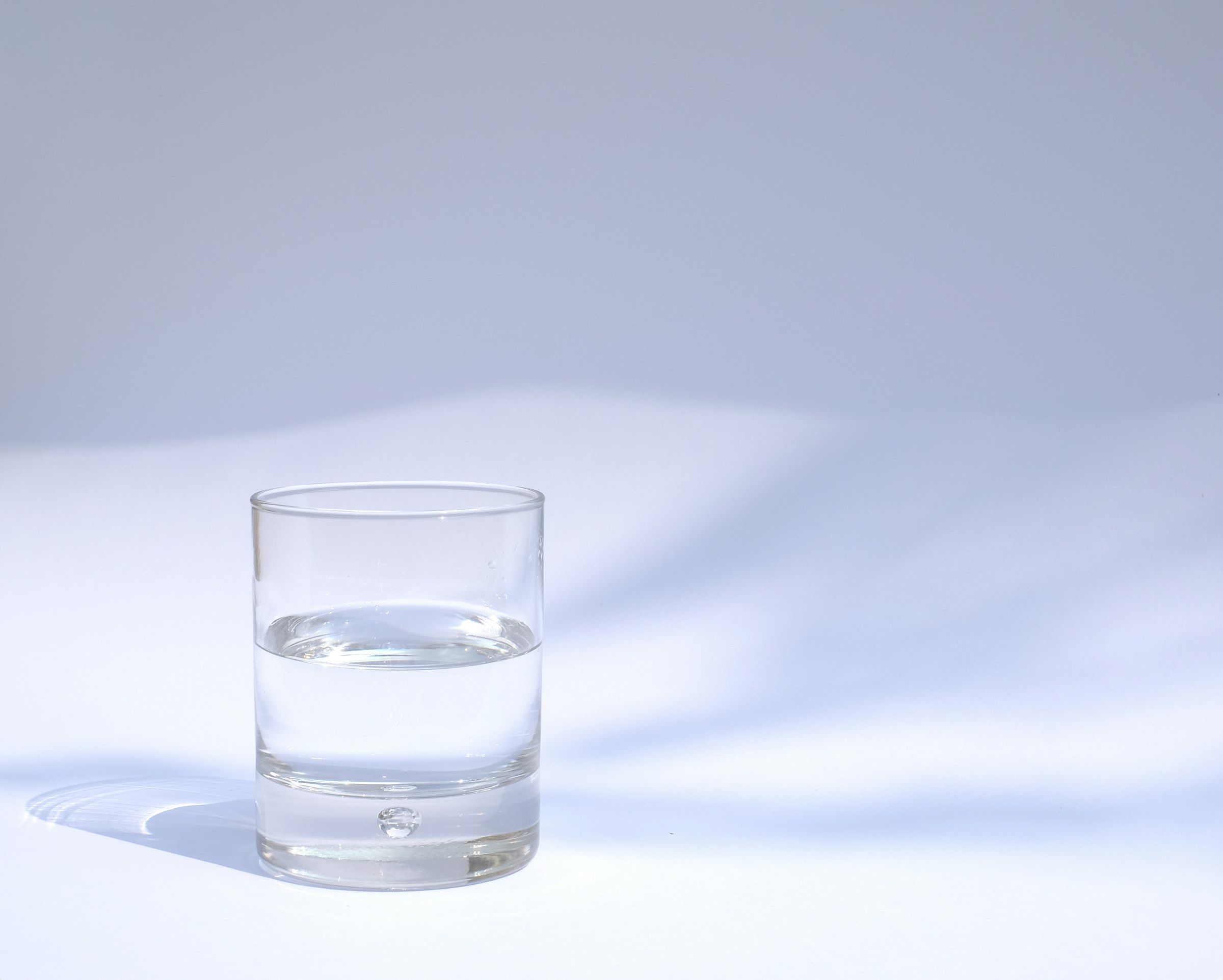 Et klart drikkeglass fylt med vann – et glass vann kan lindre tørr munn